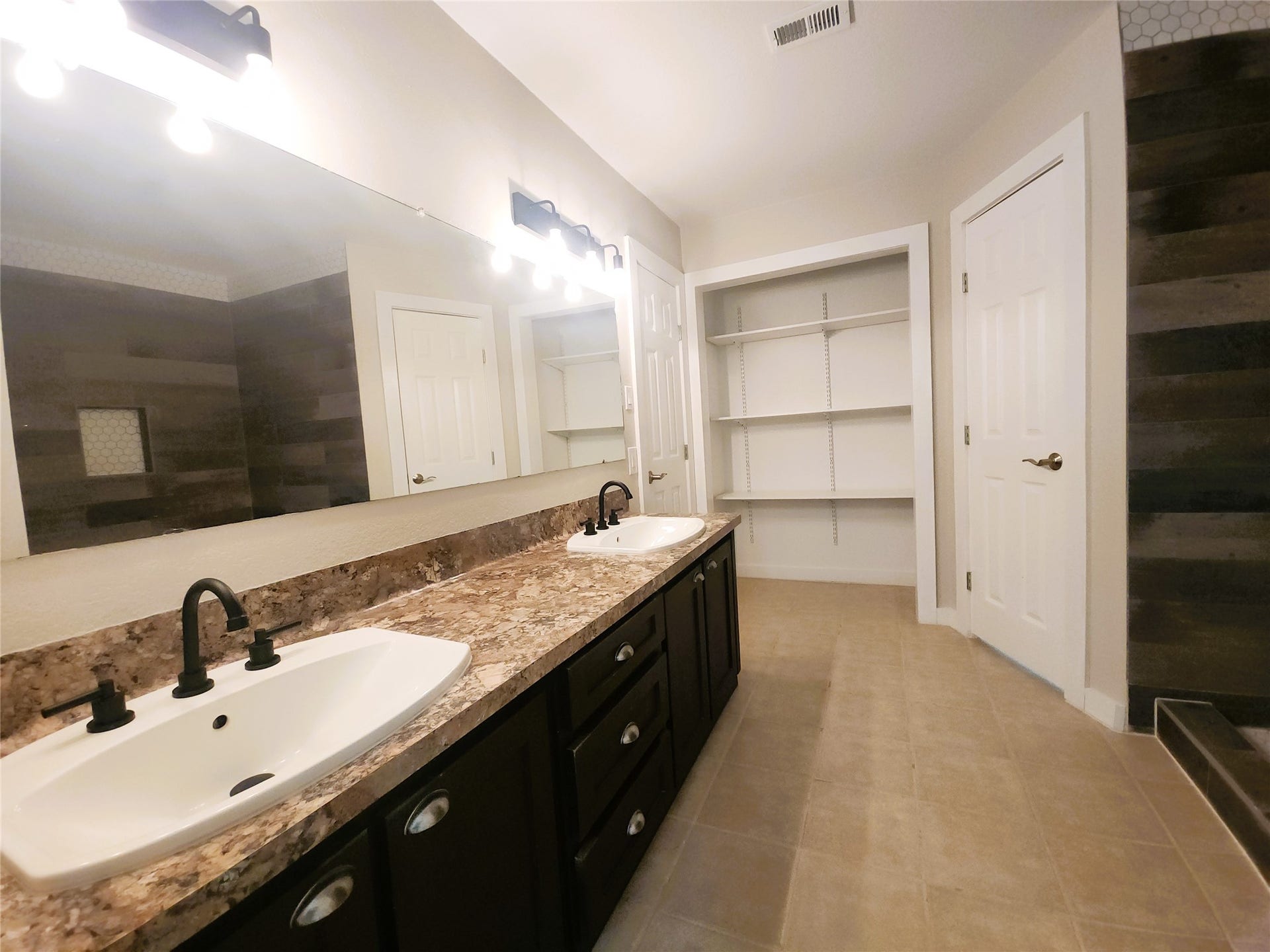 557 Fm 2693 Road E, New Waverly, TX 77358 Spacious bathroom featuring a dual-sink vanity with ample open shelving, and sleek modern fixtures.