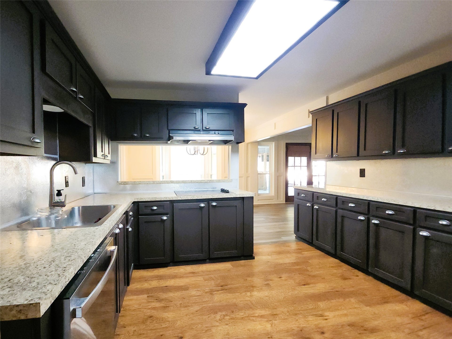 557 Fm 2693 Road E, New Waverly, TX 77358 Spacious kitchen with elegant dark cabinetry, stainless steel appliances, corner pantry and breakfast bar.