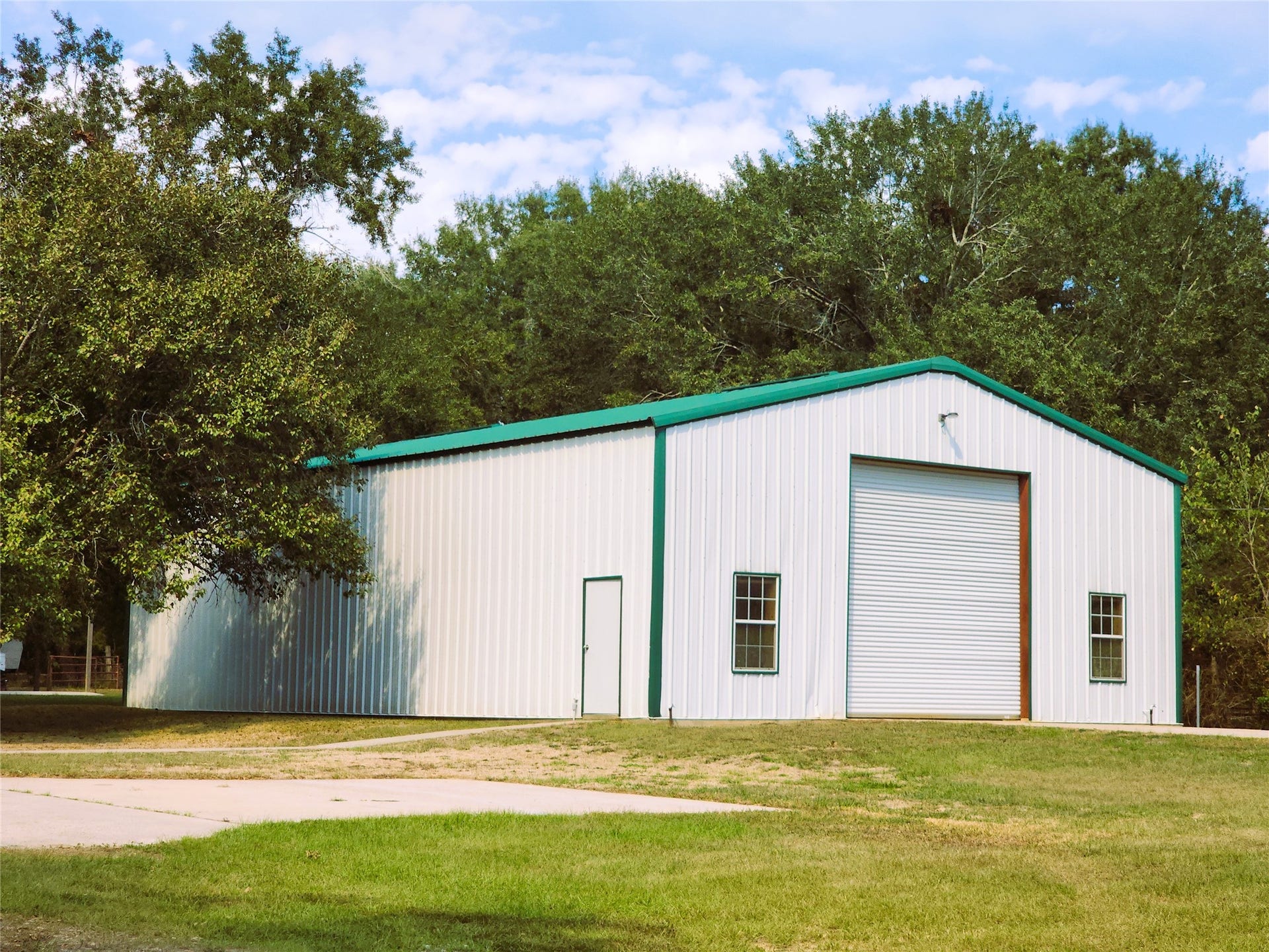 557 Fm 2693 Road E, New Waverly, TX 77358 2400 sq ft metal building featuring a 14'x14' roll-up door at each end, windows for natural light, and a mezzanine spanning the entire length of the building.