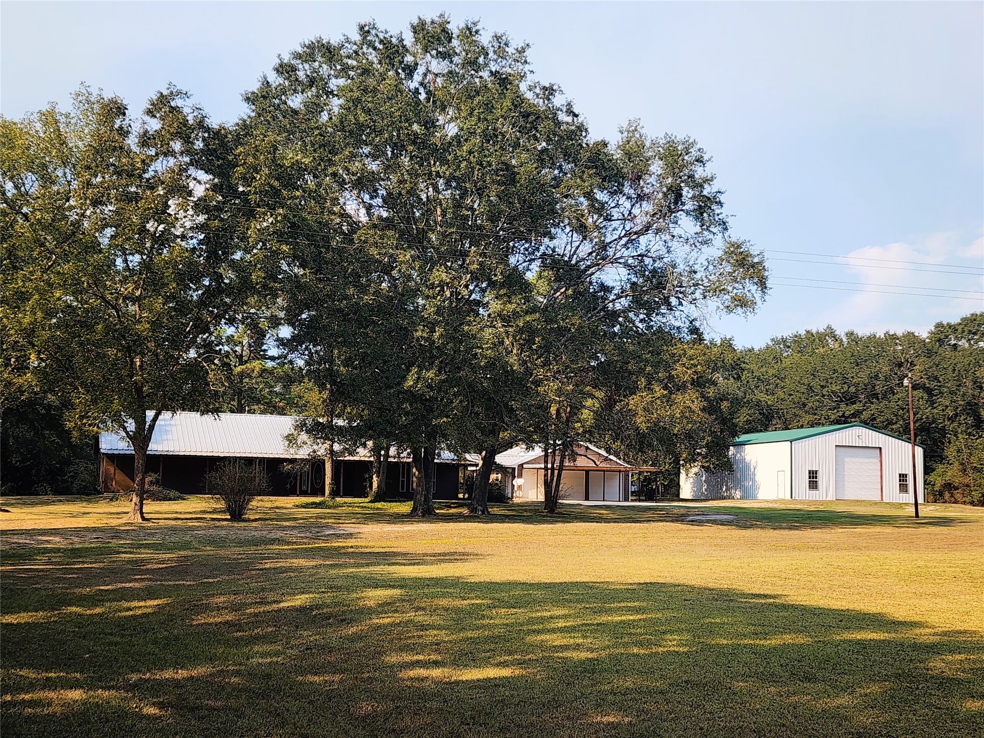 557 Fm 2693 Road E, New Waverly, TX 77358 Welcome to 557 FM 2693 East. A 5.89-acre property featuring a charming home nestled among mature trees, with a spacious lawn, pool and multiple outbuildings.