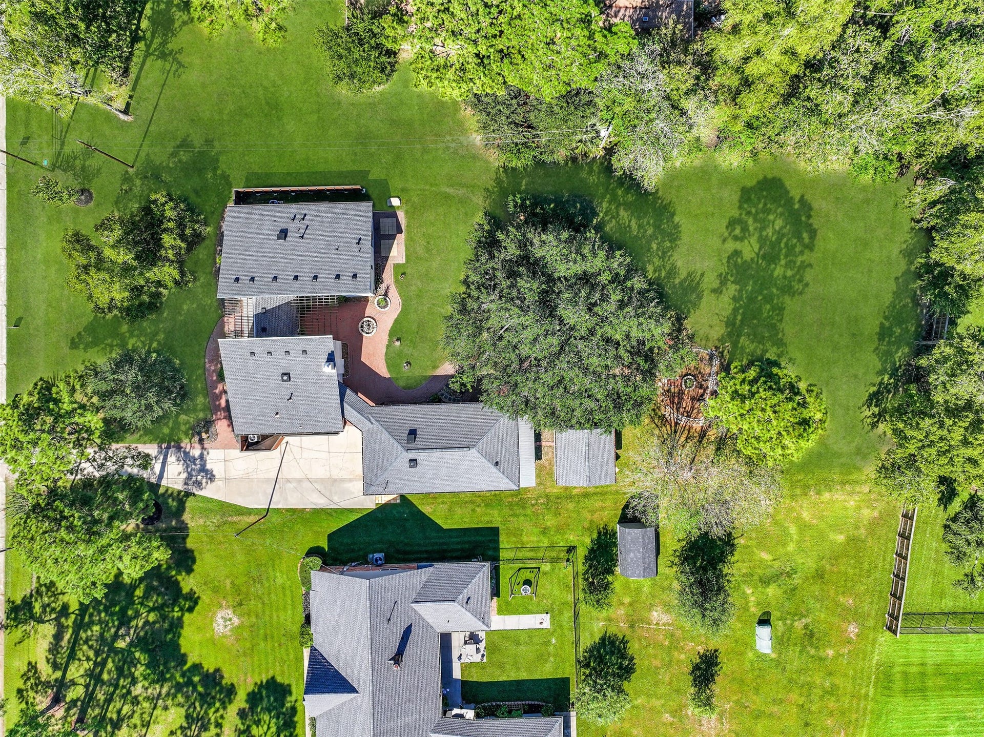 921 Falling Leaf Drive, Friendswood, TX 77546 A true birds-eye view showcases the homes unique footprint, detached garage, courtyard-style paver terrace, outdoor living areas and magnificent century oak, all surrounded by an extraordinary amount of green space on this nearly .82-acre Friendswood homesite.