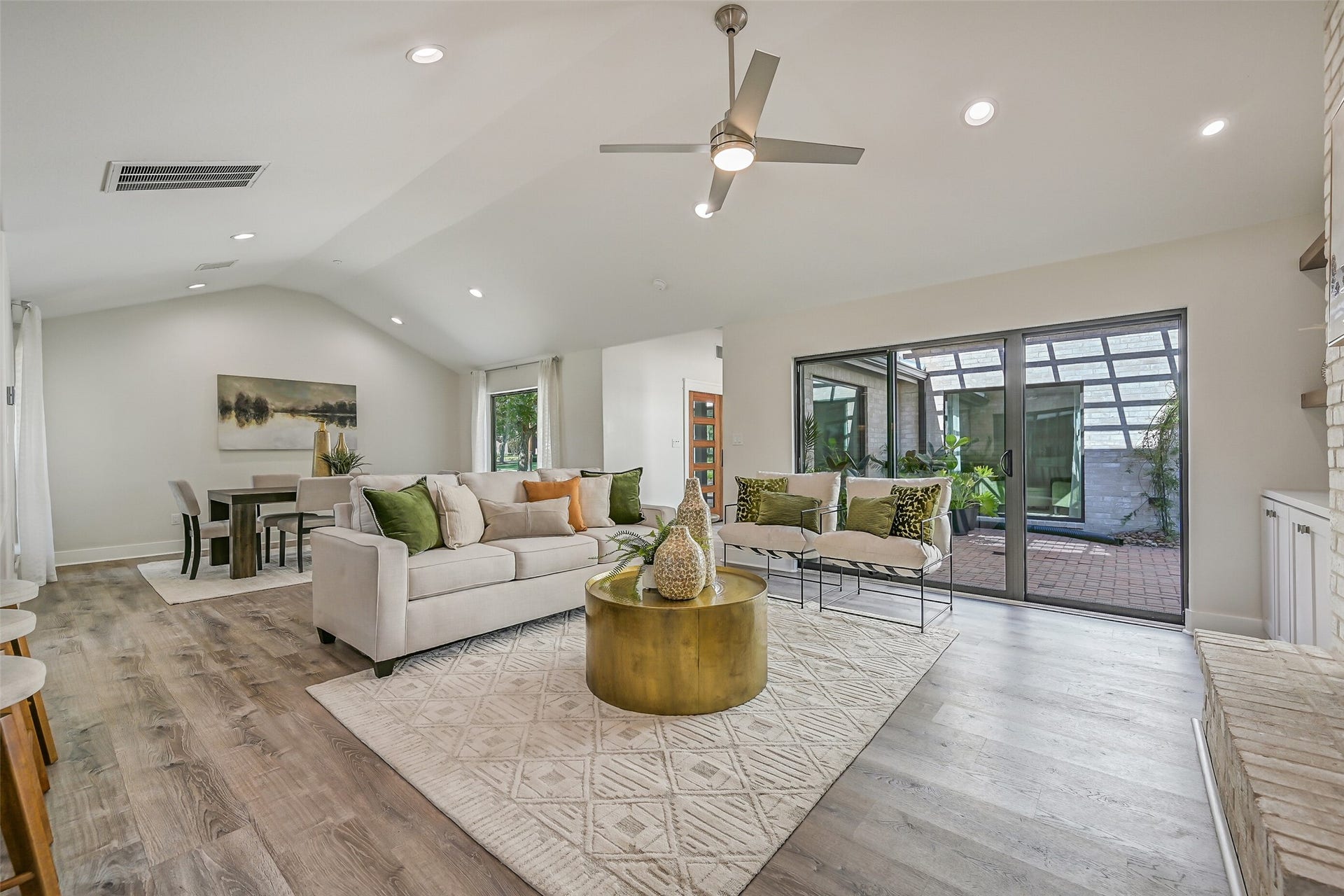 921 Falling Leaf Drive, Friendswood, TX 77546 The spacious 20' x 15' family room boasts a vaulted ceiling, recessed lighting, modern lighted ceiling fan & expansive triple sliding glass doors opening to the paver terrace, creating a seamless connection between the homes indoor and outdoor living spaces.