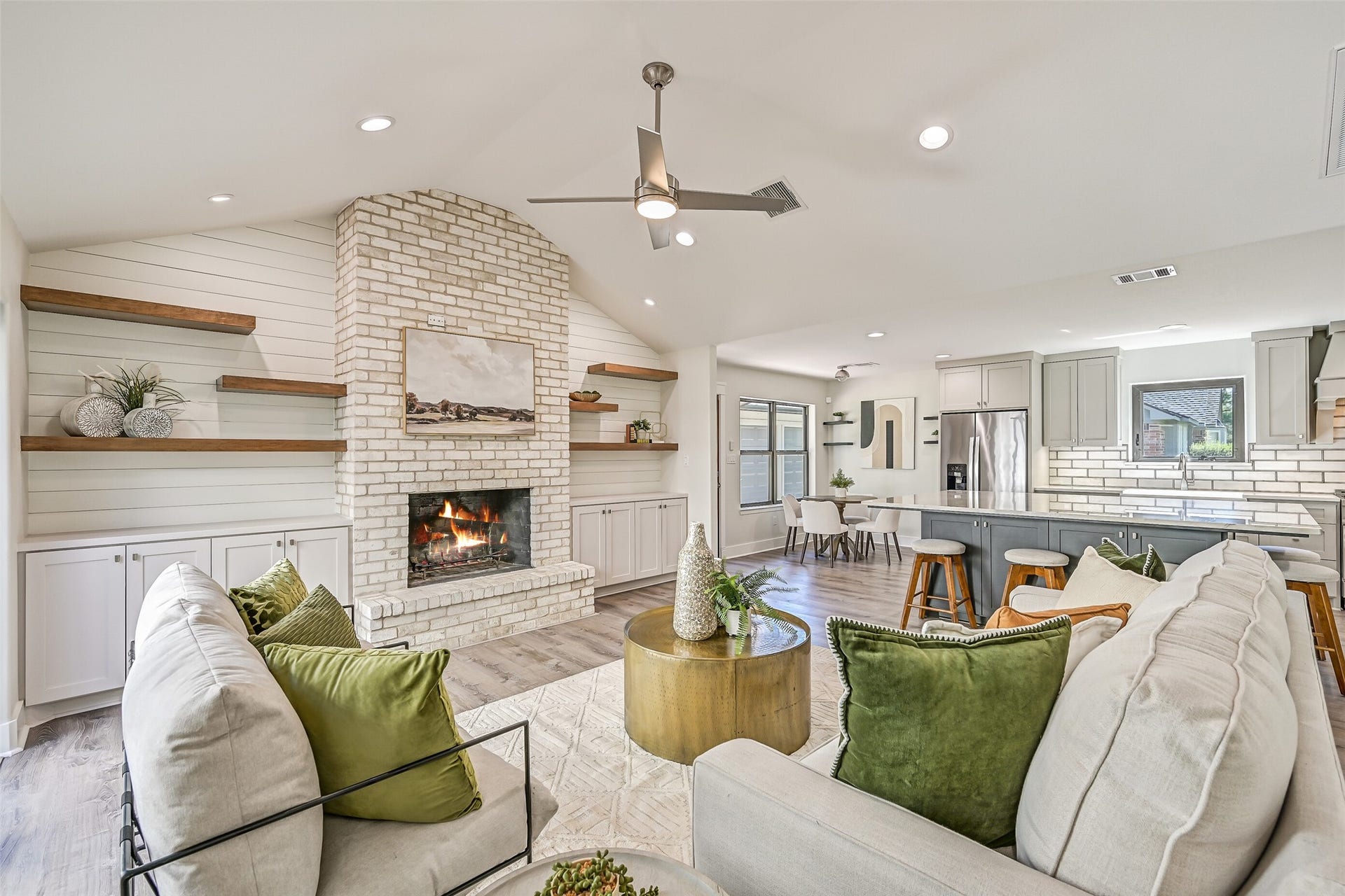 921 Falling Leaf Drive, Friendswood, TX 77546 Completely reimagined from the frame out in 2021, the open-concept family room showcases a vaulted ceiling, wood-burning brick fireplace, custom built-ins & luxury vinyl plank flooring. The extensive renovation included new electrical, plumbing, HVAC, windows, sheetrock, lighting & fixtures.