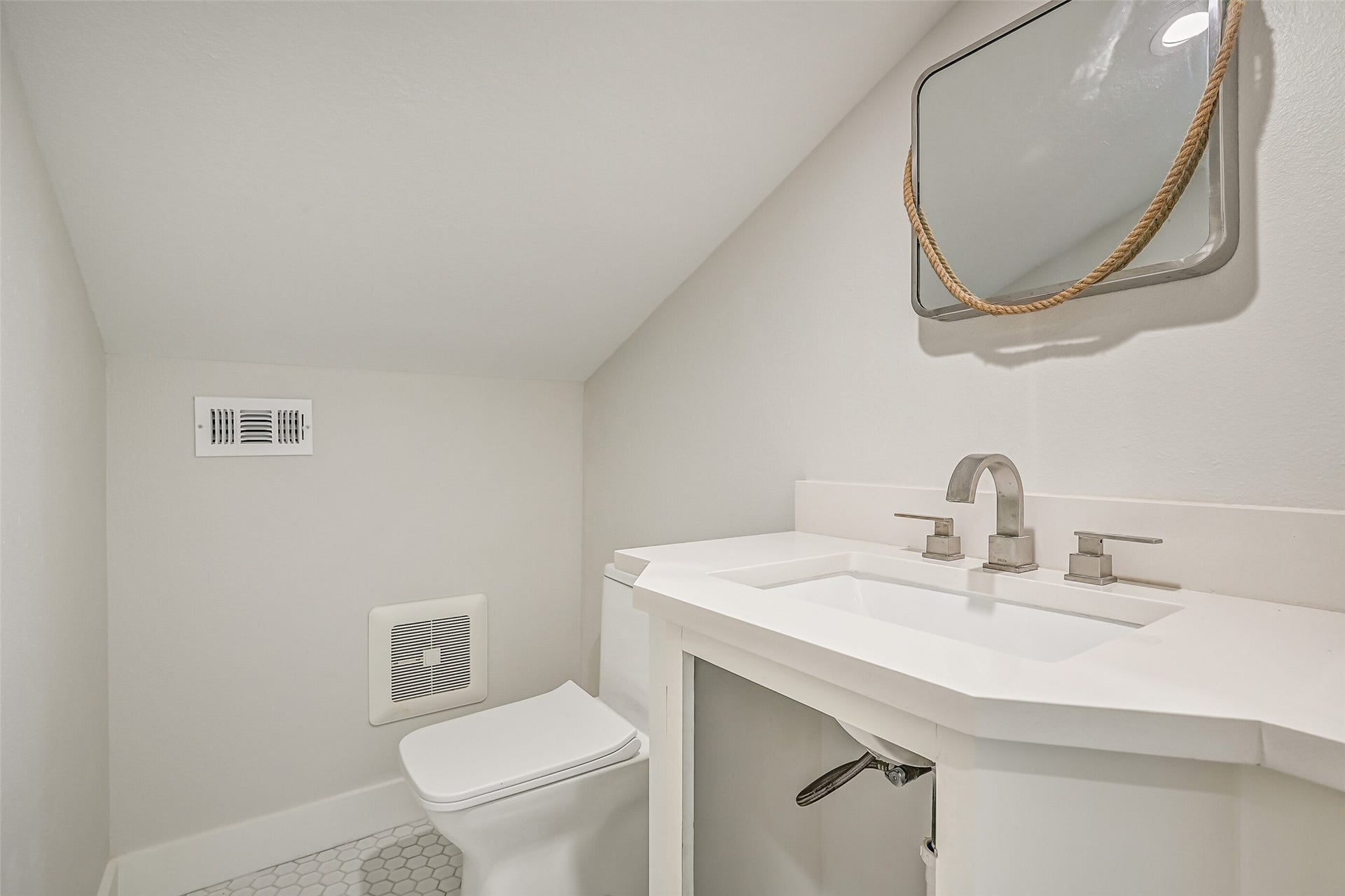 921 Falling Leaf Drive, Friendswood, TX 77546 Conveniently located off the upstairs gameroom, the half bath features a quartz-topped vanity with rectangular undermount sink, contemporary fixtures, framed mirror & classic hexagonal tile flooring beneath the charming sloped ceiling.