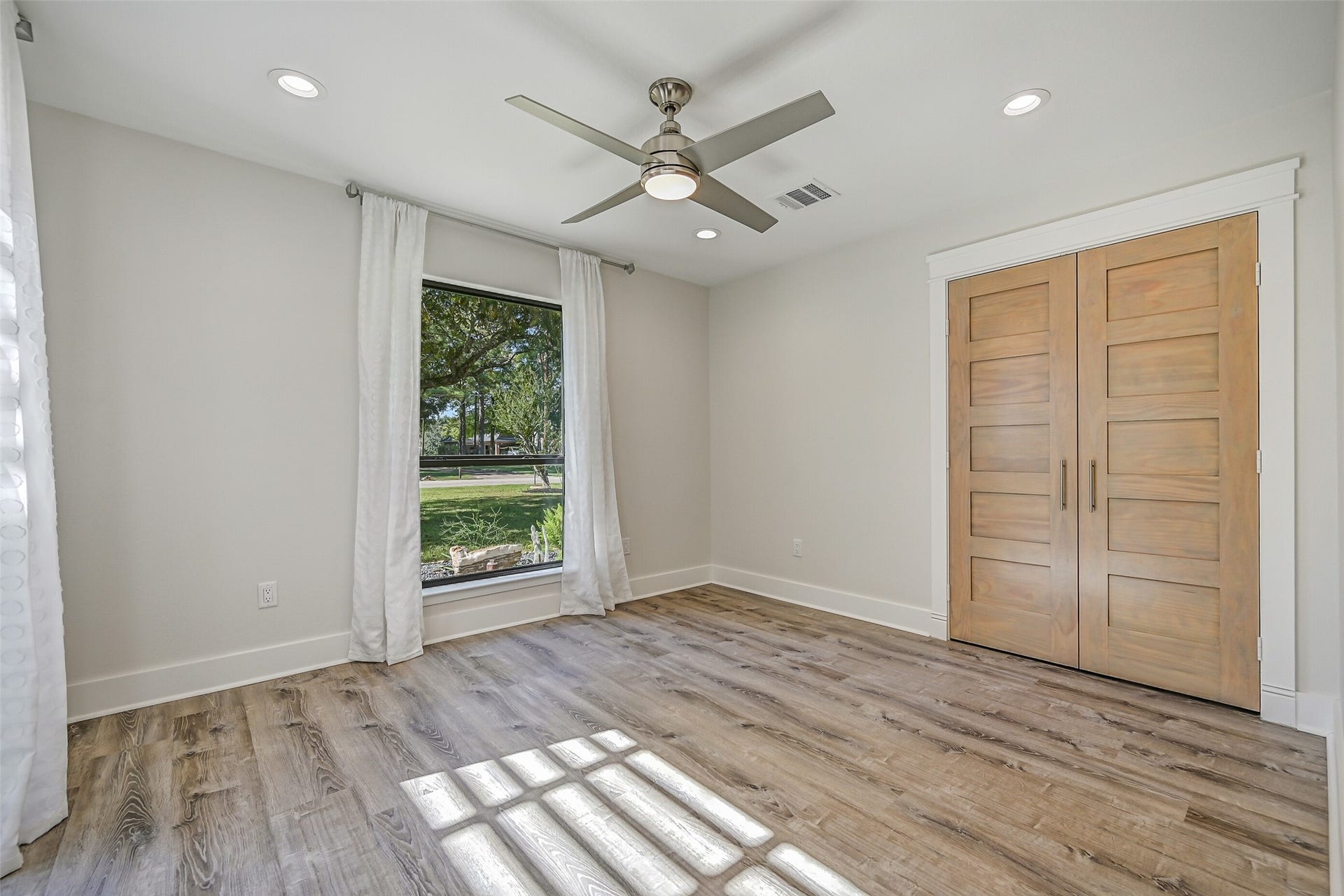 921 Falling Leaf Drive, Friendswood, TX 77546 Another view of the secondary bedroom highlights the double-door closet, contemporary solid wood doors, recessed lighting & consistent luxury vinyl plank flooring found throughout the beautifully redesigned home.