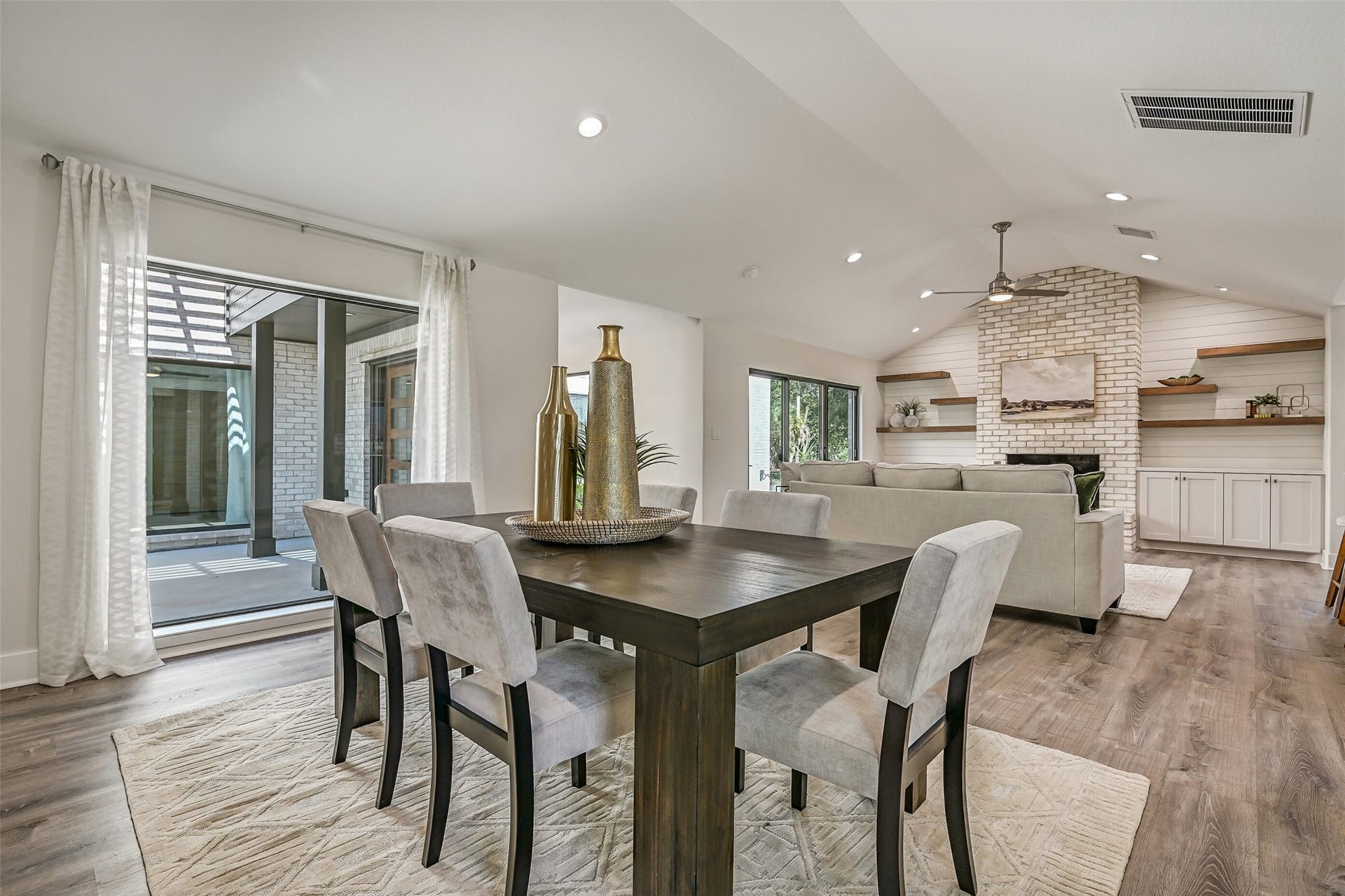 921 Falling Leaf Drive, Friendswood, TX 77546 A wide-open layout connects the dining and family rooms while changing ceiling heights subtly define each space. Oversized windows, neutral finishes & luxury vinyl plank floors continue throughout, with easy access to the central terrace just outside.