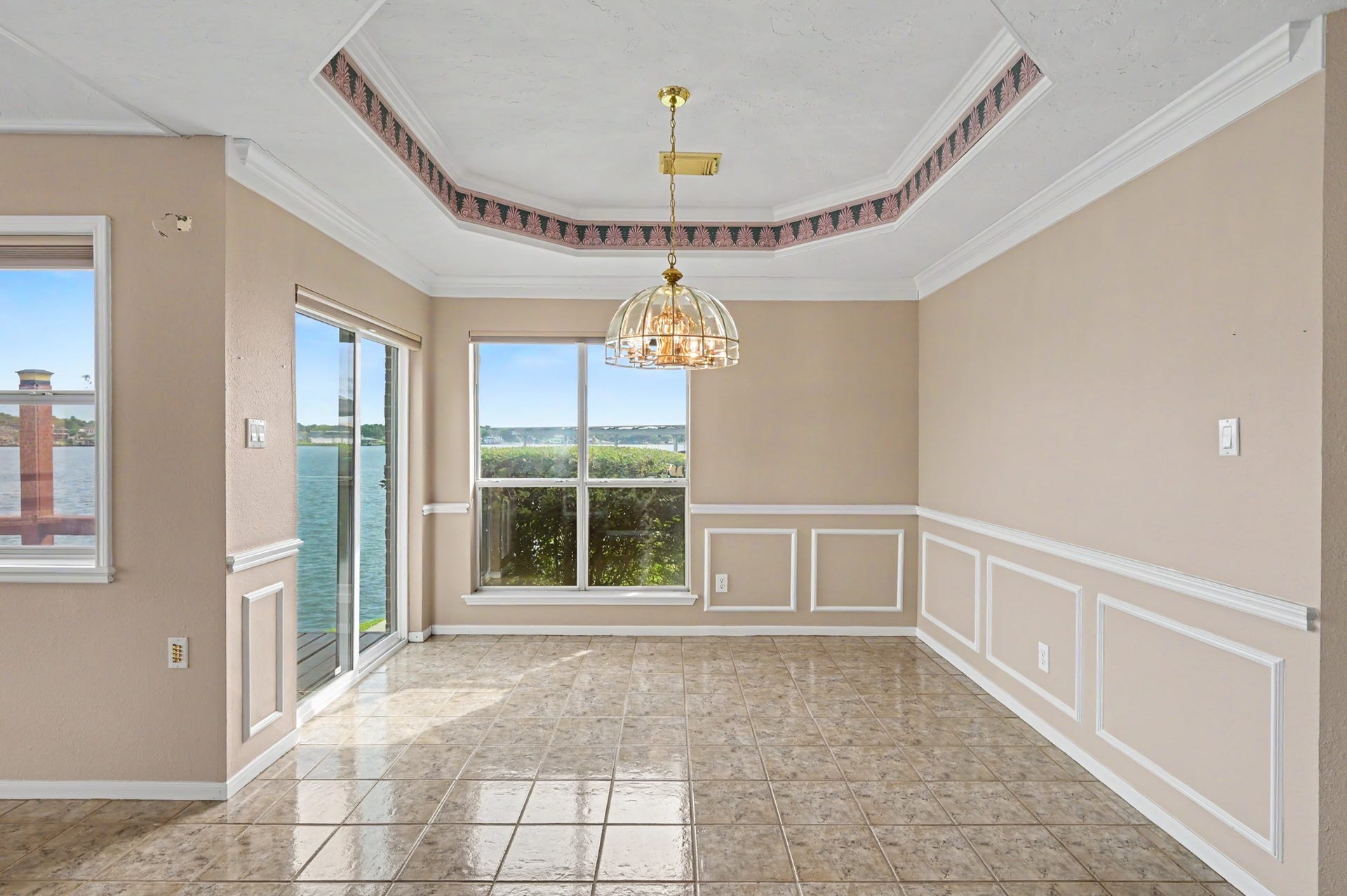 12842 Pelican Island Drive, Willis, TX 77318 Dining Room complete with tray ceiling, chair railing and wainscoting. Sliding glass door leads to wrap around porch- a perfect spot for a grill!
