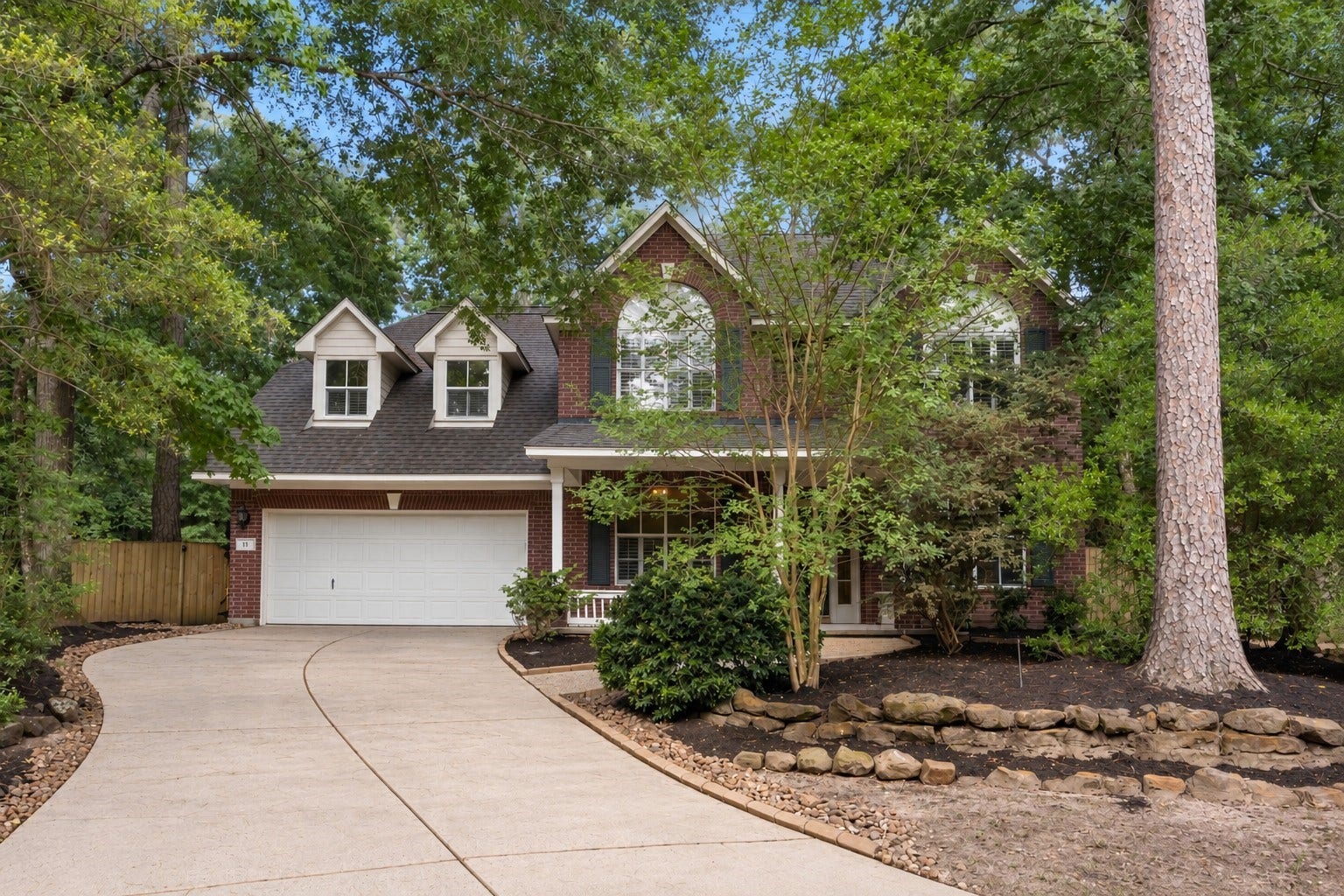11 Alden Glen Court, The Woodlands, TX 77382 Front Elevation Stately brick traditional nestled among mature trees in the heart of The Woodlands. This beautifully maintained 5-bedroom home offers timeless curb appeal, lush landscaping, and a welcoming front porch just minutes from top-rated schools, parks, shopping, and dining.