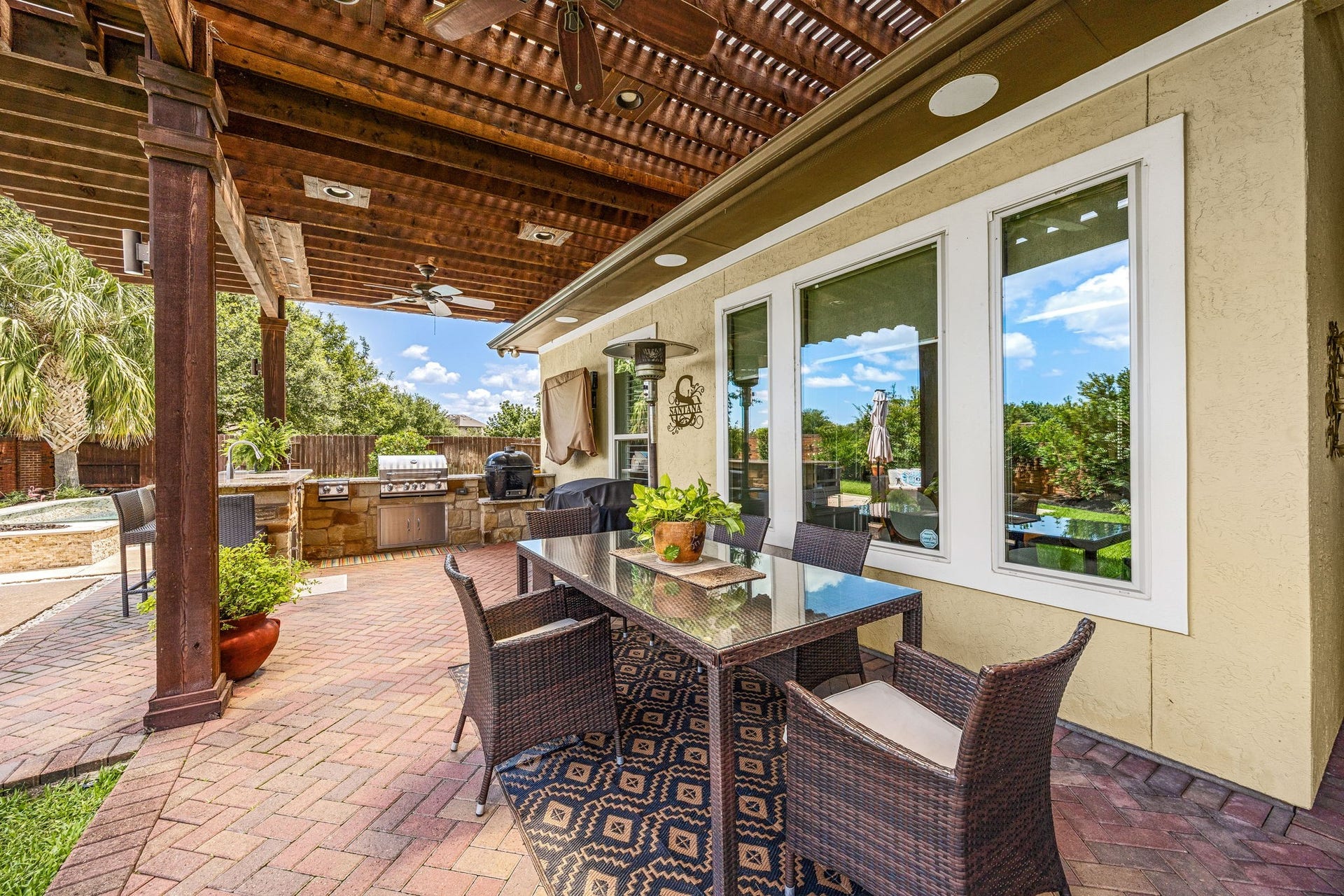 5102 Hawthorne Bend Drive, Katy, TX 77494 Al fresco living at its finest! This expansive covered patio features a stunning wood pergola, recessed lighting, ceiling fans, brick pavers, and a direct view of the outdoor kitchen and pool, the perfect outdoor escape!