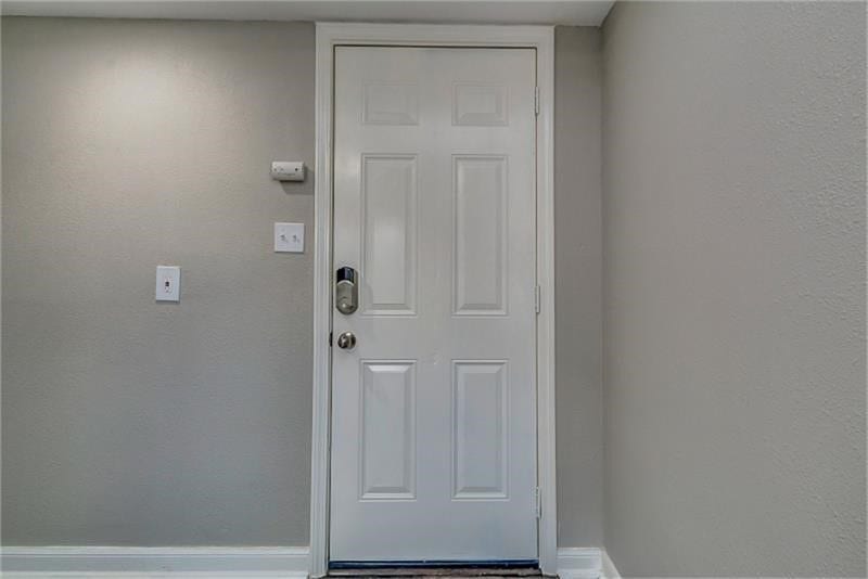 3502 Rosedale Street, Houston, TX 77004 Entryway featuring a modern white door with a sleek keypad lock, set against neutral-toned walls for a welcoming ambiance.
