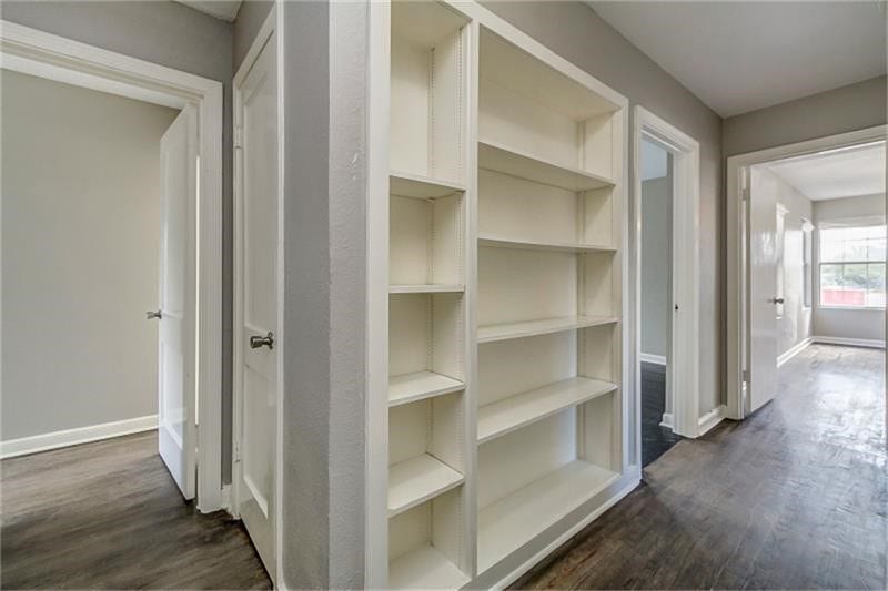 3502 Rosedale Street, Houston, TX 77004 Hallway with built-in shelving, leading to spacious rooms with ample natural light and hardwood floors.