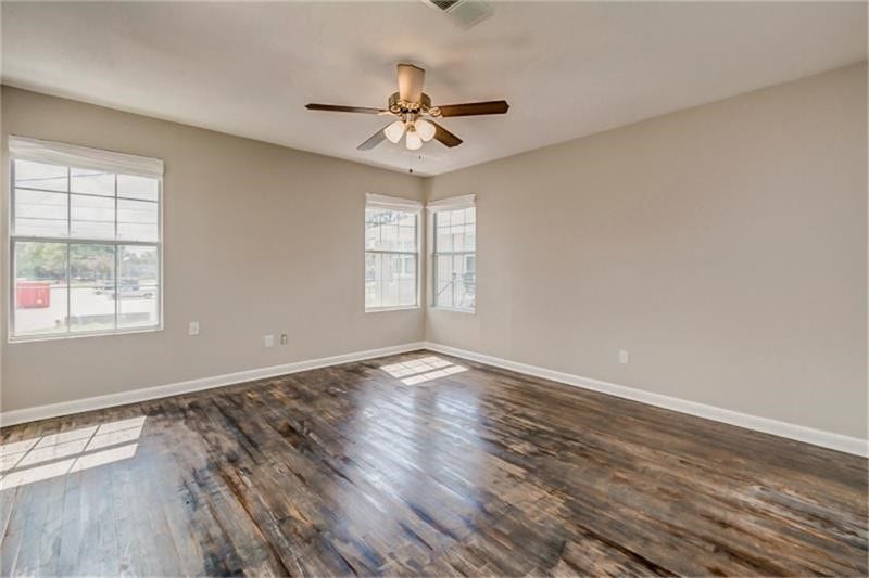 3502 Rosedale Street, Houston, TX 77004 Room with rich hardwood floors, abundant natural light from multiple windows, and a ceiling fan for comfort.