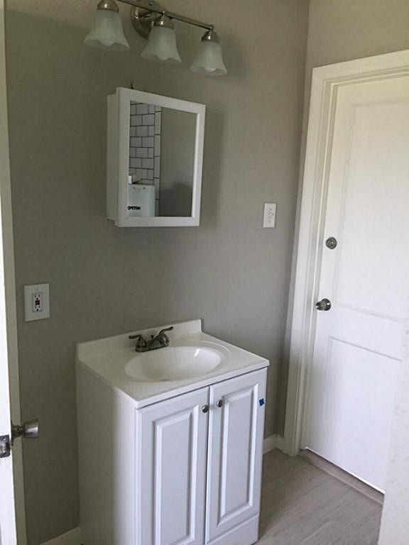 3502 Rosedale Street, Houston, TX 77004 Bathroom features a sleek white vanity with ample storage, complemented by a modern mirror cabinet and elegant light fixture.