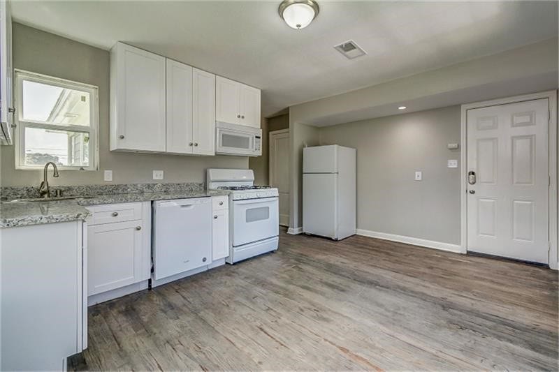 3502 Rosedale Street, Houston, TX 77004 Bright white cabinetry and modern appliances create a clean, contemporary kitchen.