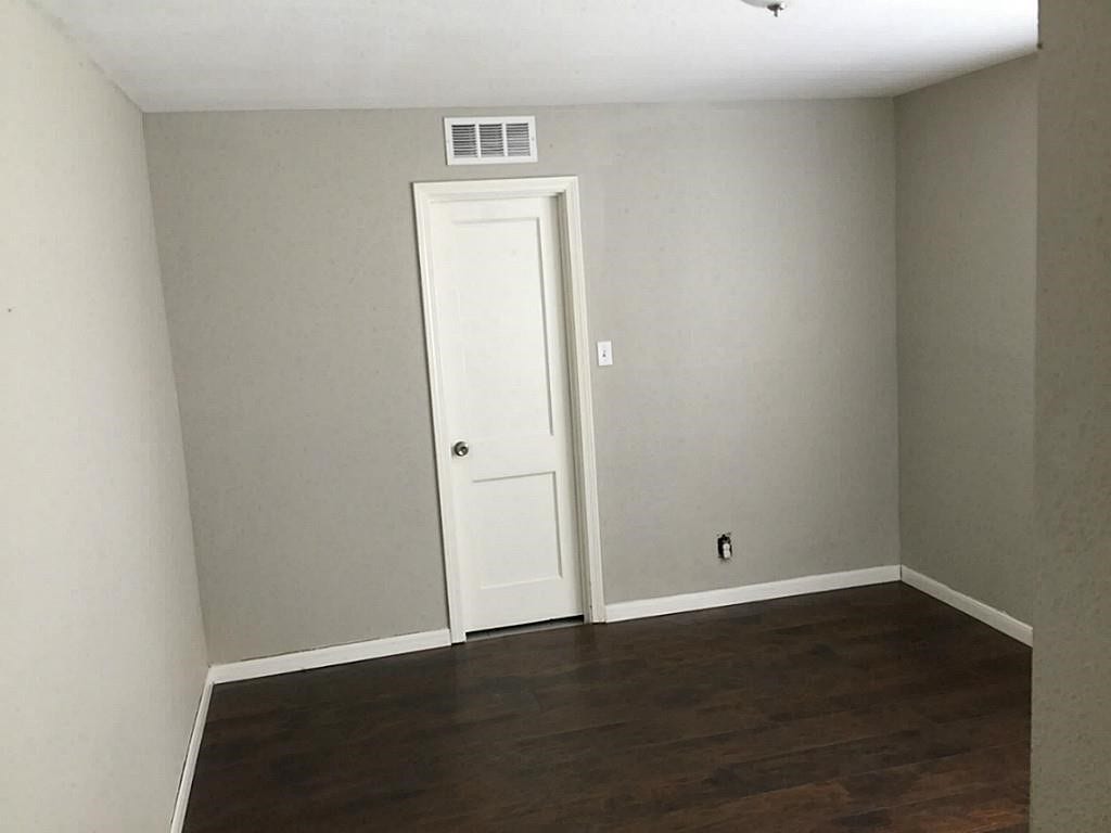 3502 Rosedale Street, Houston, TX 77004 Room with neutral walls and rich, dark hardwood flooring, offering a clean slate for personalization.