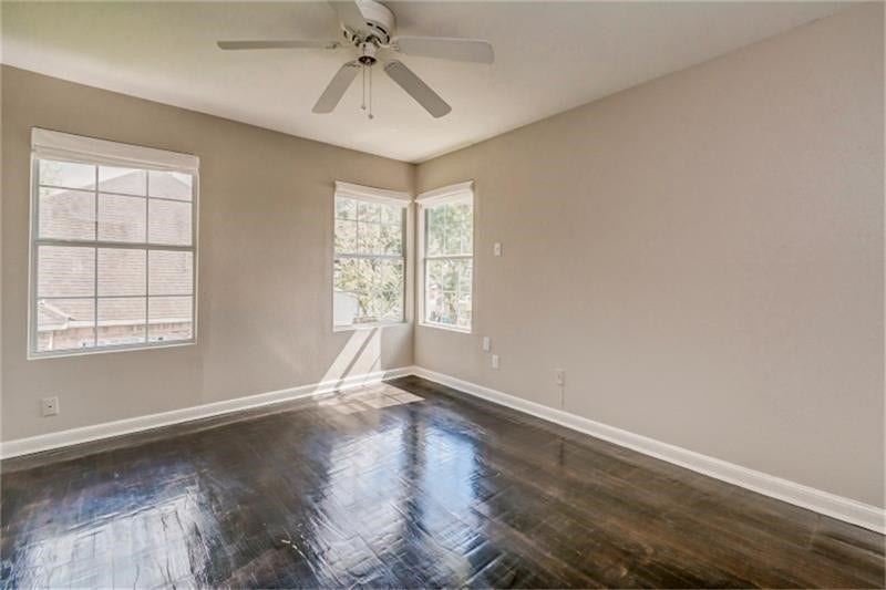 3502 Rosedale Street, Houston, TX 77004 Bright and airy bedroom with gleaming hardwood floors, large windows, and a ceiling fan, offering a serene and inviting atmosphere.