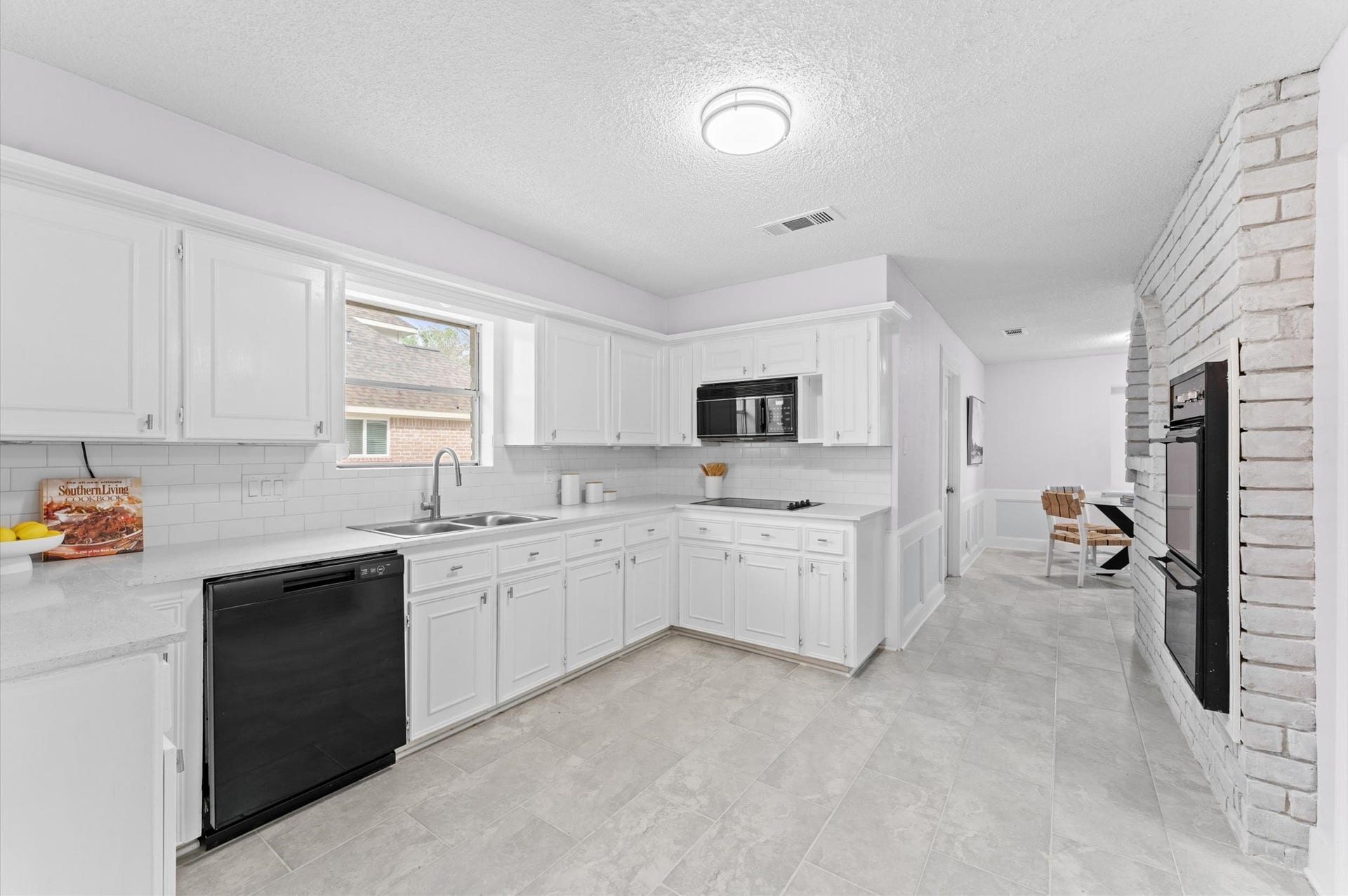 The kitchen includes a glass-topped electric cooktop, stainless steel appliances, a double-basin sink, and more room than you can imagine for ease of moving about.