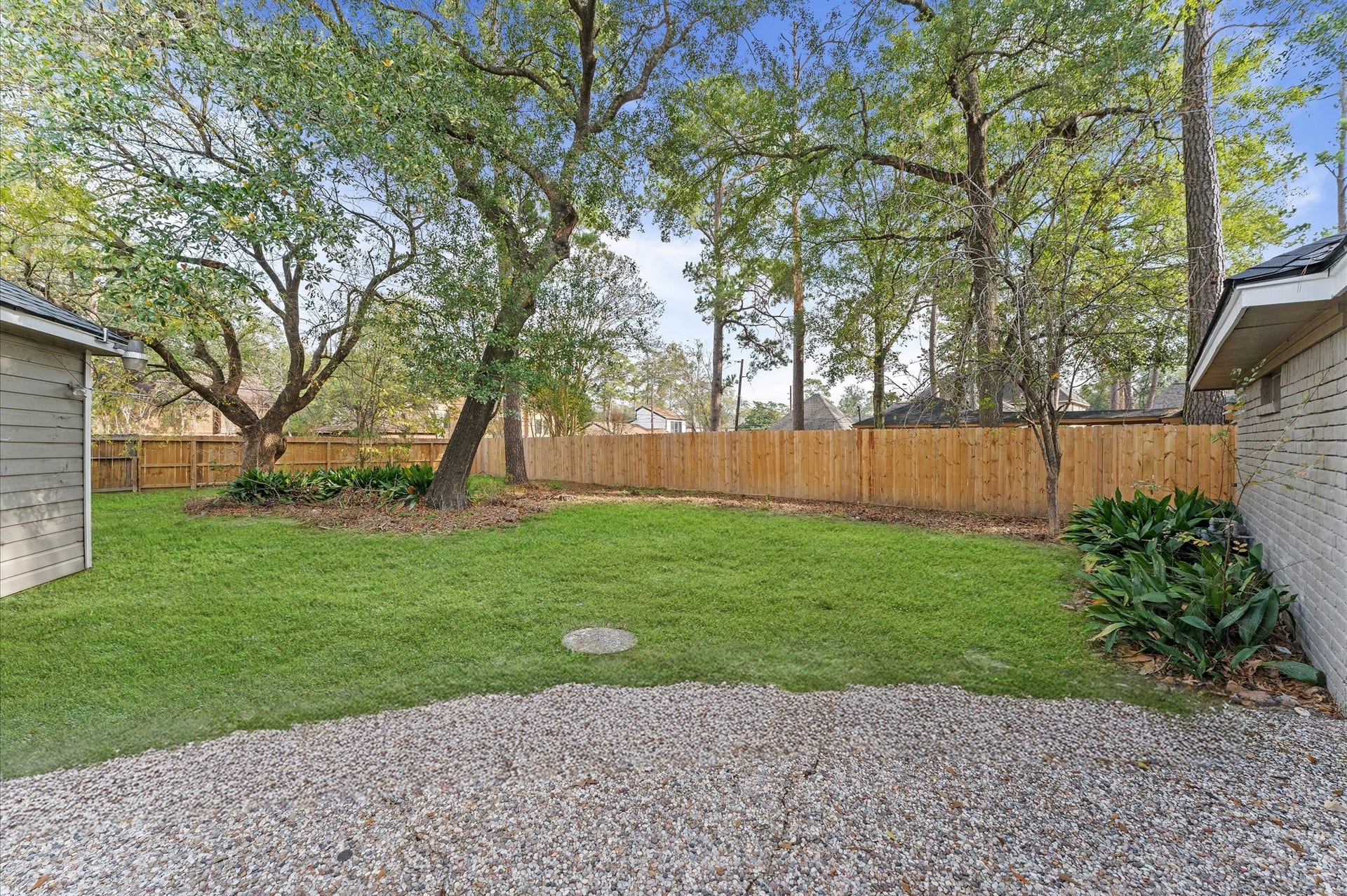 The patio offers this view of a gorgeous backyard surrounded by shade trees.
