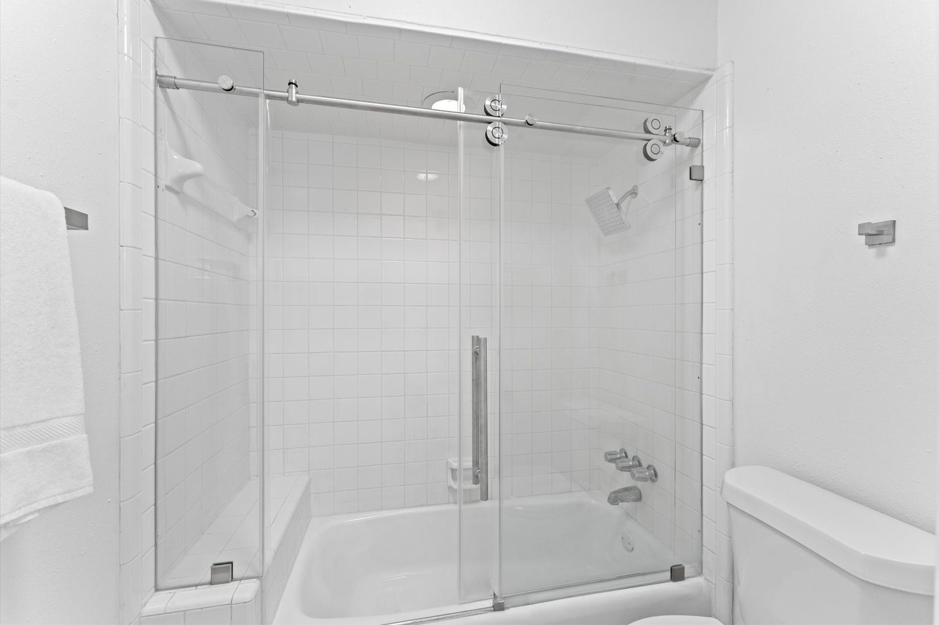 The second bathroom includes a frameless shower with a built-in bench.