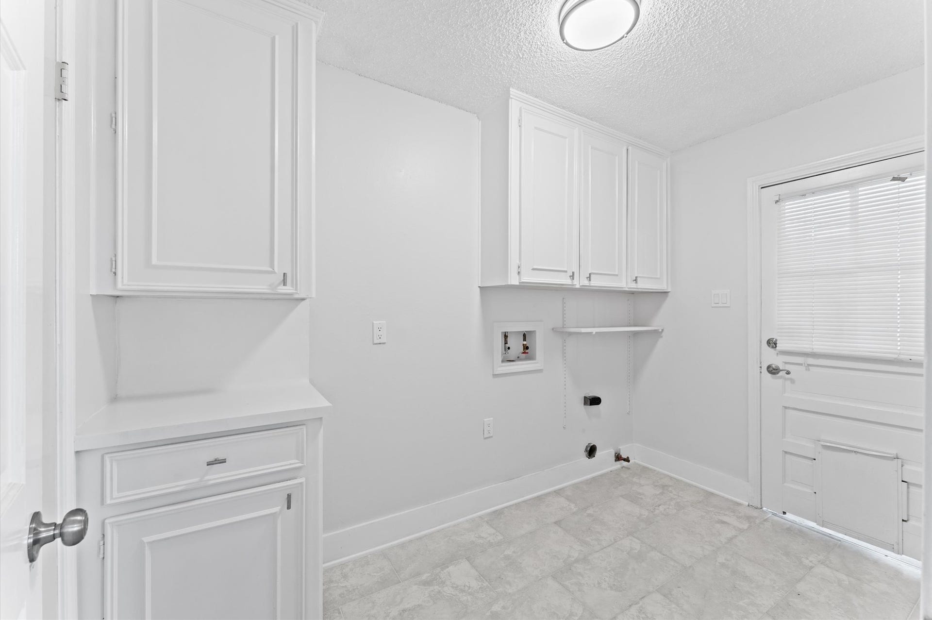 Laundry day just got easier in this space that offers cabinets for storage and space for a full-sized washer and dryer.