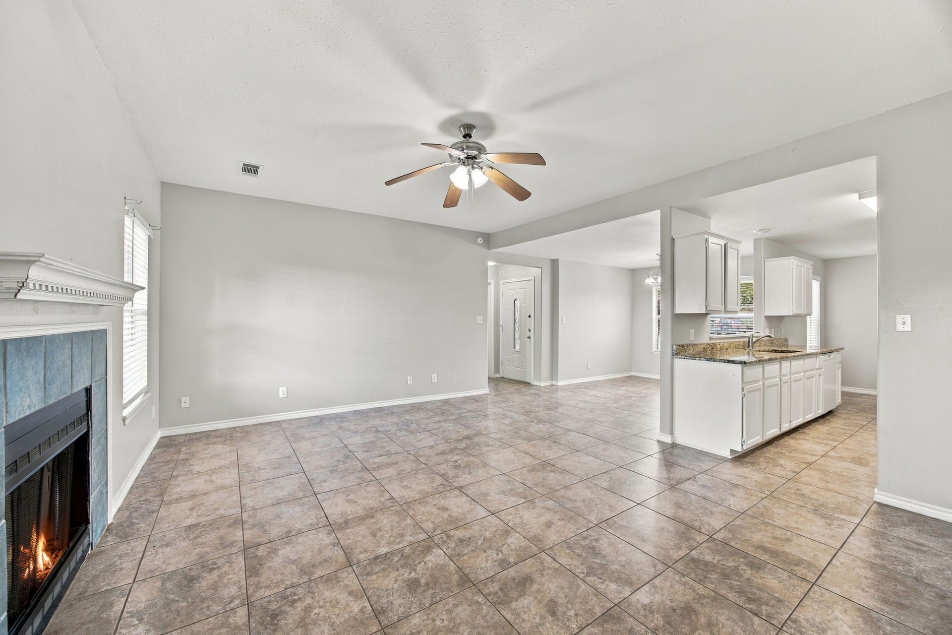 23619 Summer Pine Drive, Spring, TX 77373 Warm neutral tones set the mood for this open concept living area featuring tile flooring, and a cozy fireplace that seamlessly connect the kitchen and dining room.