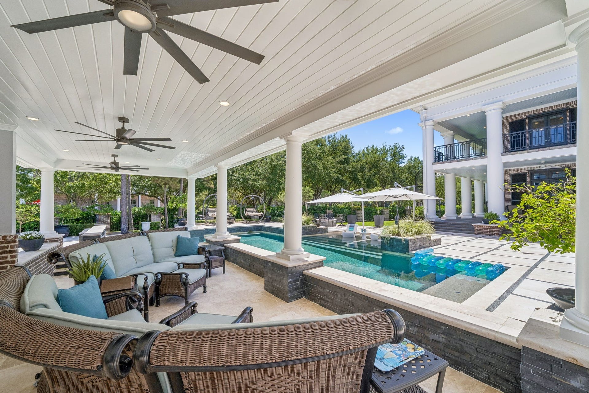 2 Georgian Row, The Woodlands, TX 77380 The covered outdoor pavilion offers a front-row view of the resort-style pool and the homes impressive rear architecture. Columned construction, a paneled ceiling with recessed lighting and multiple ceiling fans create a true outdoor living room overlooking the pool, courtyard, and grand two-story veranda.