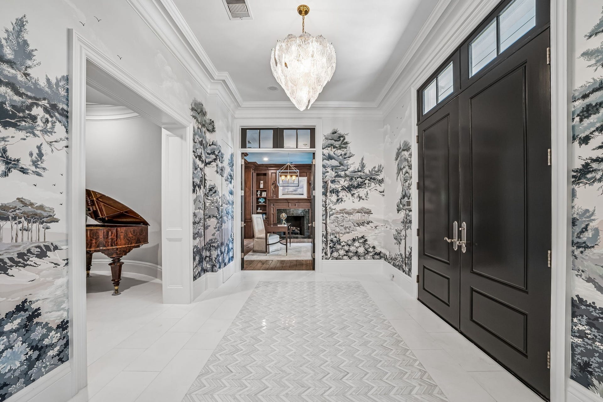 2 Georgian Row, The Woodlands, TX 77380 A completely redesigned entry sets an elegant tone with marble flooring, custom scenic wall murals, refined millwork, and a statement chandelier. Hidden closet doors are seamlessly incorporated into the design for a polished, uninterrupted finish.