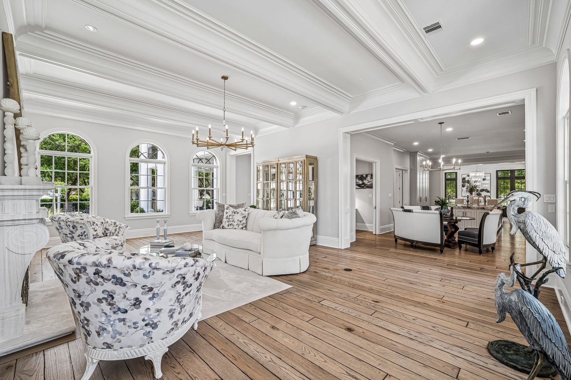 2 Georgian Row, The Woodlands, TX 77380 This view highlights the incredible ceiling detail and open flow of the formal living room into the dining area and kitchen, creating an expansive layout ideal for entertaining.