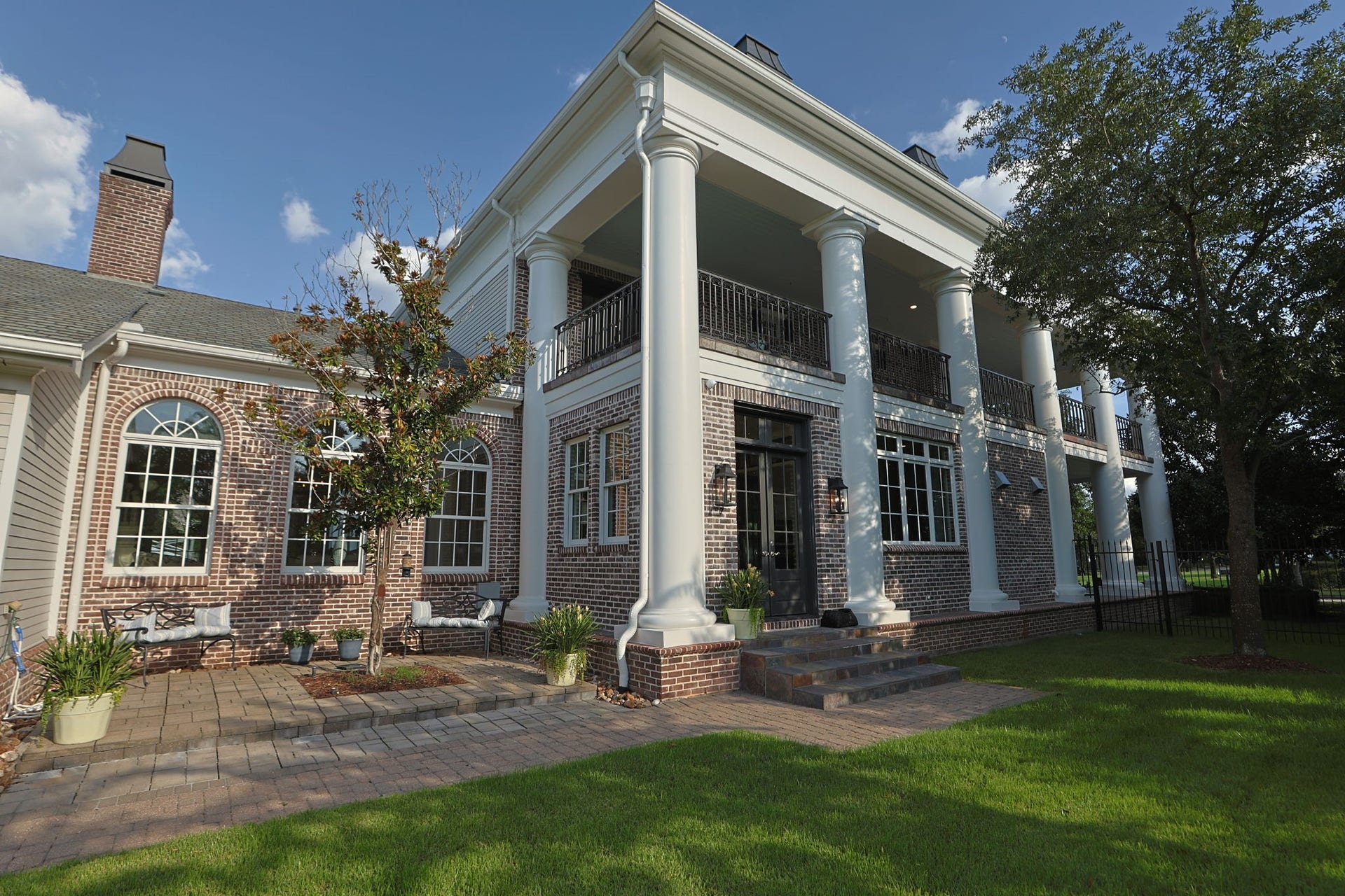 2 Georgian Row, The Woodlands, TX 77380 The side elevation is equally impressive, showcasing the homes stately brick architecture, soaring columns, graceful arched windows, and expansive two-story veranda. Mature landscaping and a private lawn complete this beautifully composed exterior. This entry is a hall to the breakfast area with the Chef's Kitchen to the right.