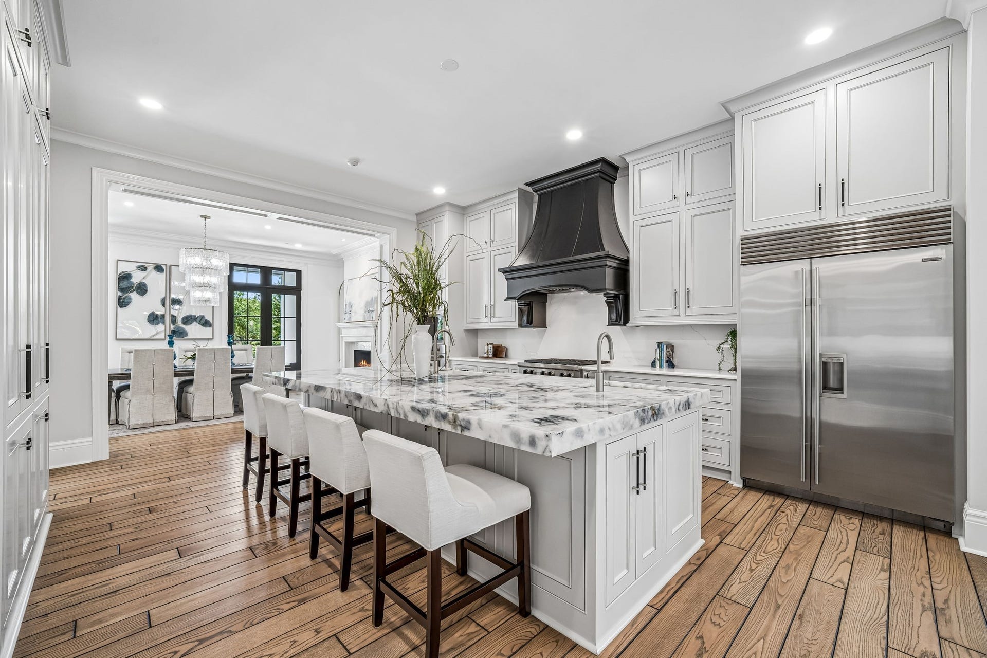 2 Georgian Row, The Woodlands, TX 77380 Another view of the main kitchen highlights the impressive scale of the island, abundant custom cabinetry and seamless connection to the formal dining roomideal for both everyday living and large-scale entertaining.