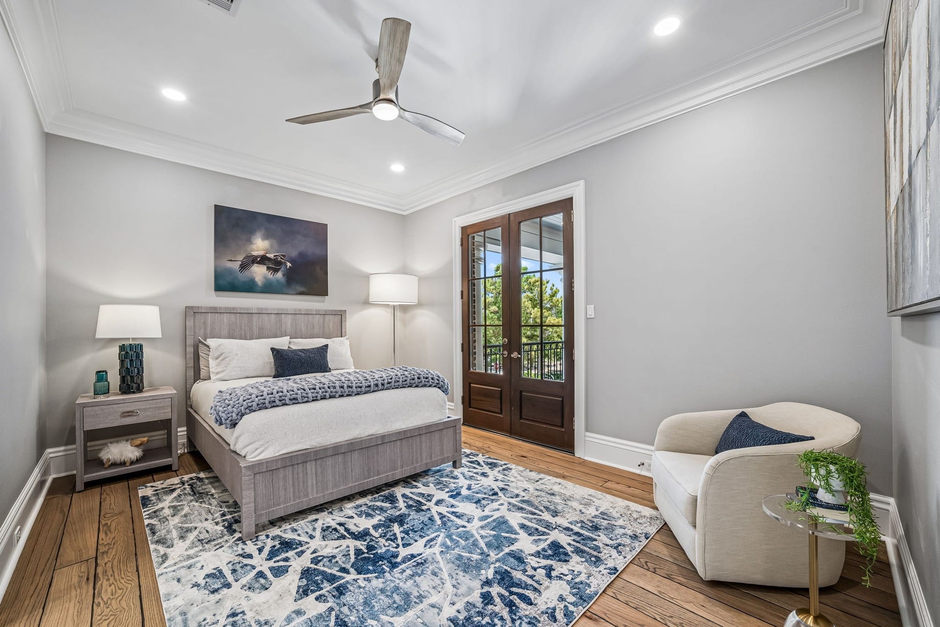 2 Georgian Row, The Woodlands, TX 77380 Bright secondary bedroom featuring hardwood floors, crown molding, recessed lighting, ceiling fan, and French doors opening directly to the covered veranda.
