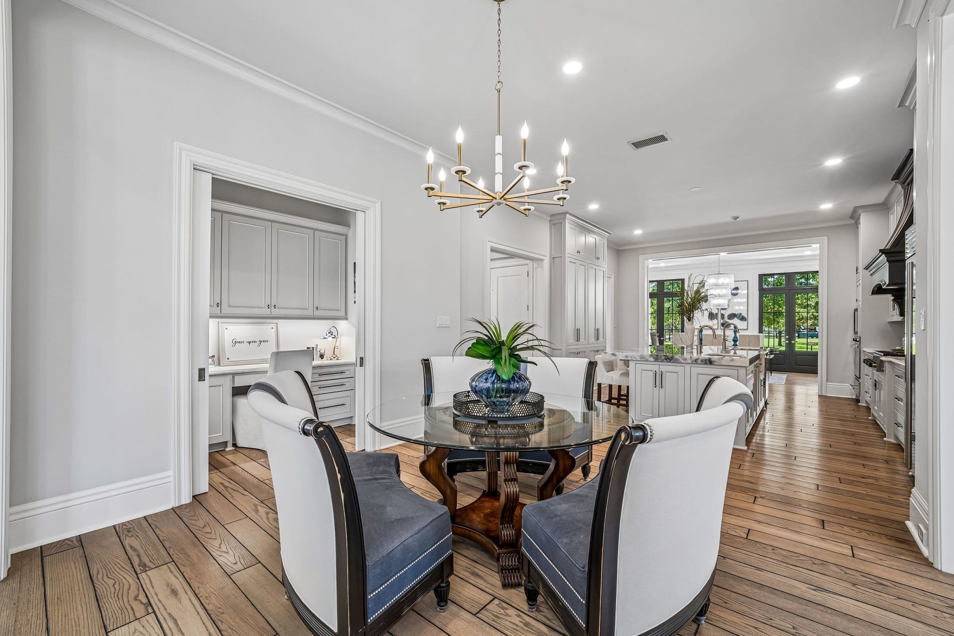 2 Georgian Row, The Woodlands, TX 77380 Bright breakfast room positioned just off the kitchen, featuring a statement chandelier and an open layout that creates an inviting setting for everyday dining. Office nook can be closed off with pocket doors.