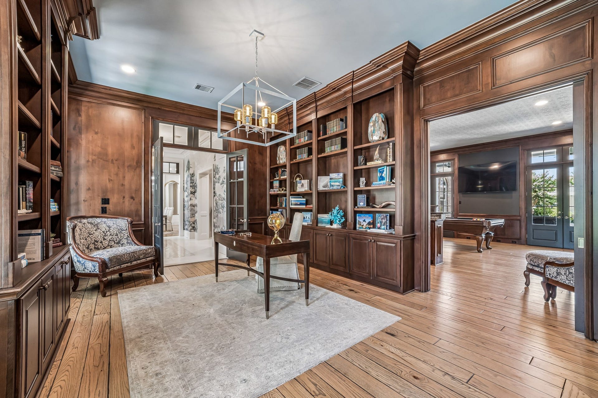 2 Georgian Row, The Woodlands, TX 77380 Richly appointed private study/library featuring custom floor-to-ceiling woodwork and built-ins, a fireplace, and French doors opening directly to the veranda. The woodwork has been professionally refinished and sealed, preserving the rooms warmth and architectural character.