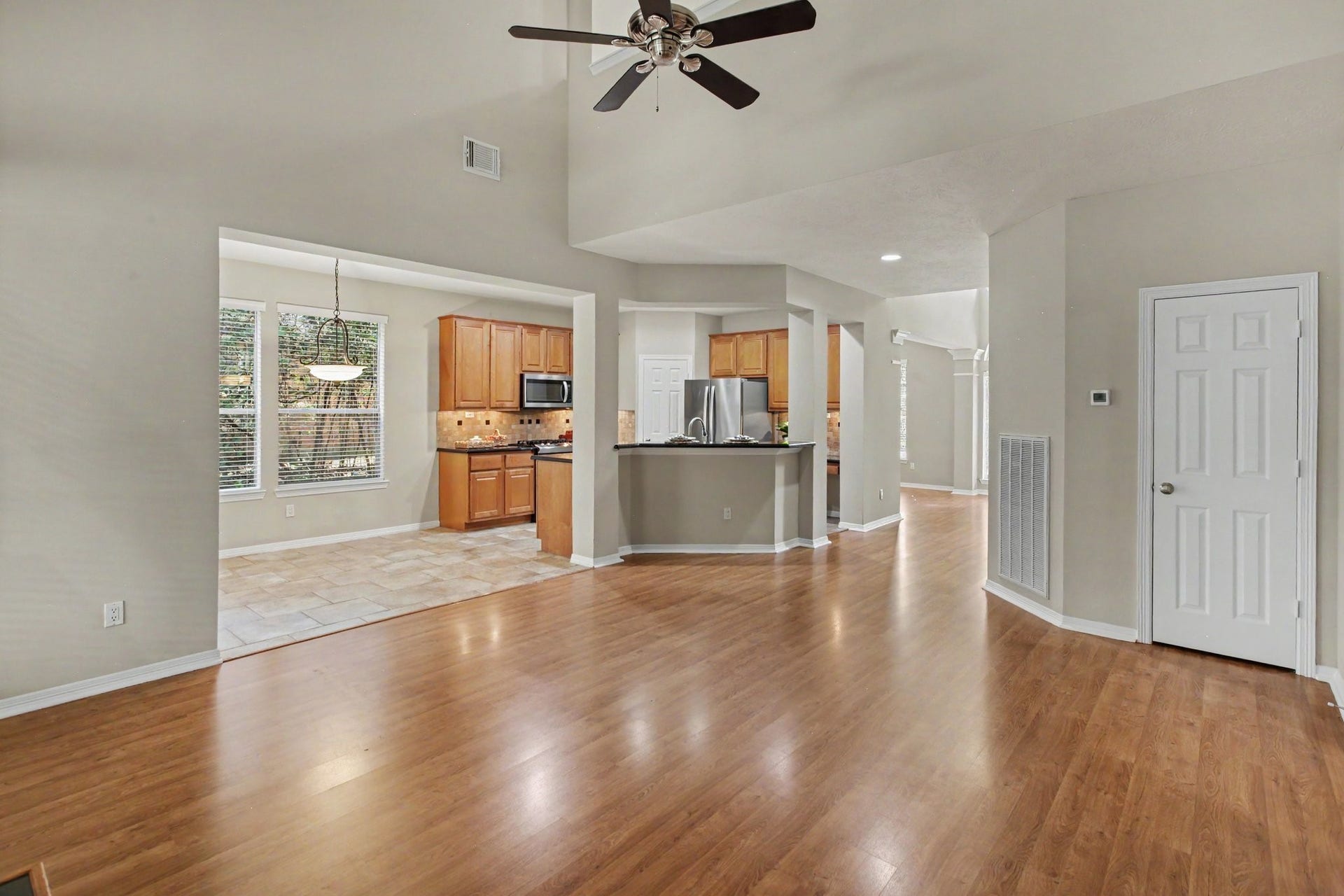 42 S Peaceful Canyon Circle, The Woodlands, TX 77381 An additional view of the living room looking into the breakfast nook and kitchen with breakfast bar seating and a working desk inside the kitchen. The home has digital thermostats both up and down for your desired comfort.