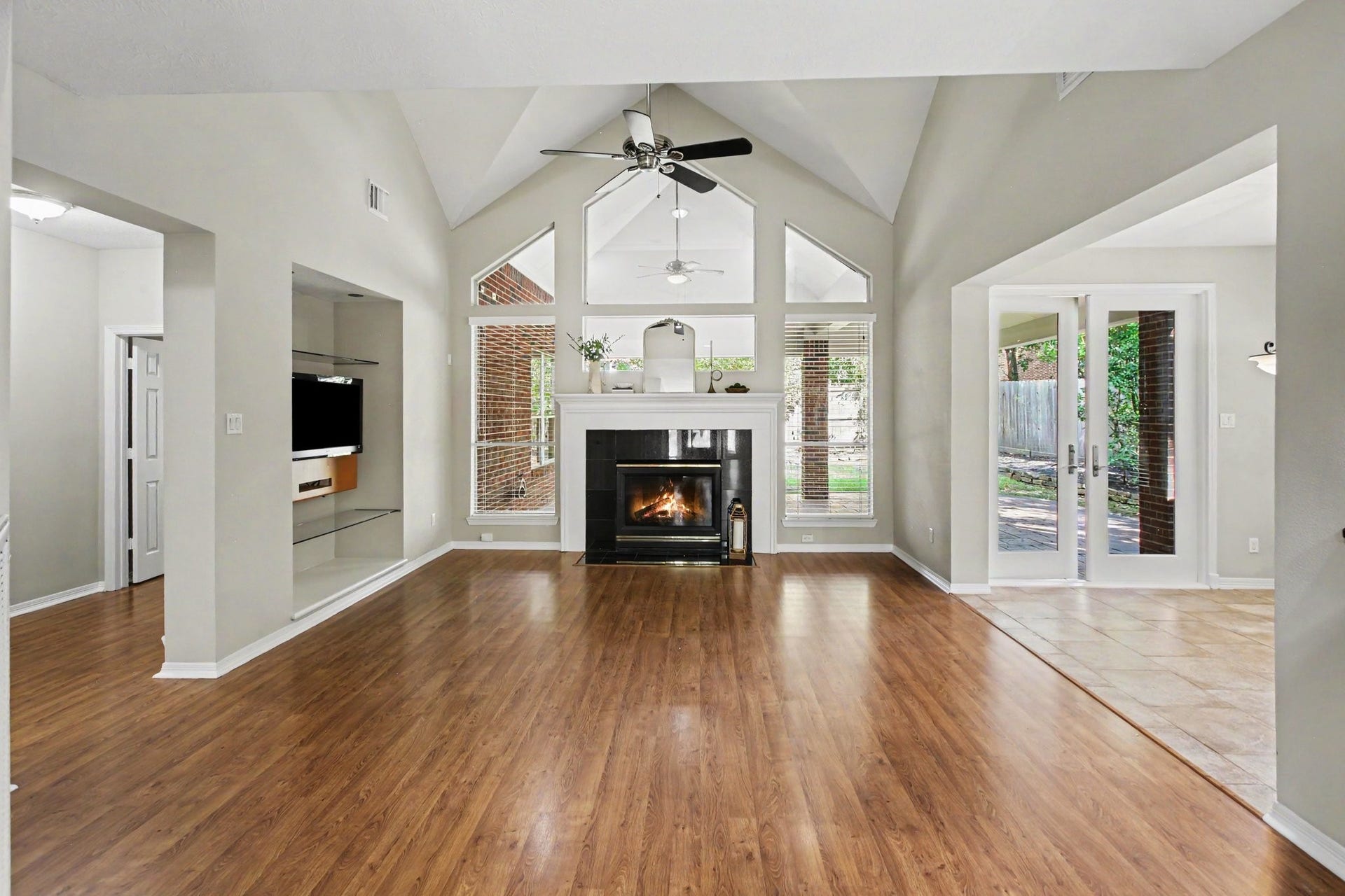 42 S Peaceful Canyon Circle, The Woodlands, TX 77381 Gorgeous vaulted ceilings and natural light enhance the living room with beautiful, gleaming floors and a gaslog fireplace. The TV with mount is available to stay in the home.