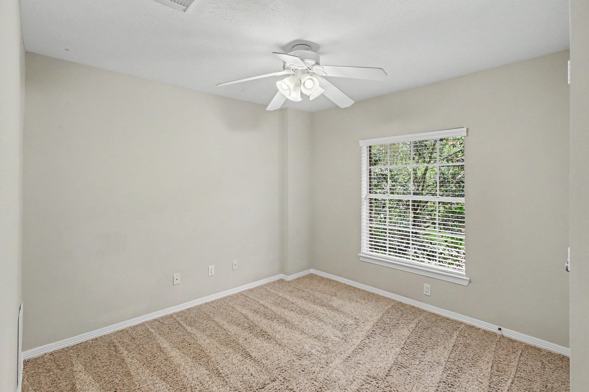 42 S Peaceful Canyon Circle, The Woodlands, TX 77381 This secondary bedroom upstairs with comfy carpet and a full closet, sits at the front of the house.
