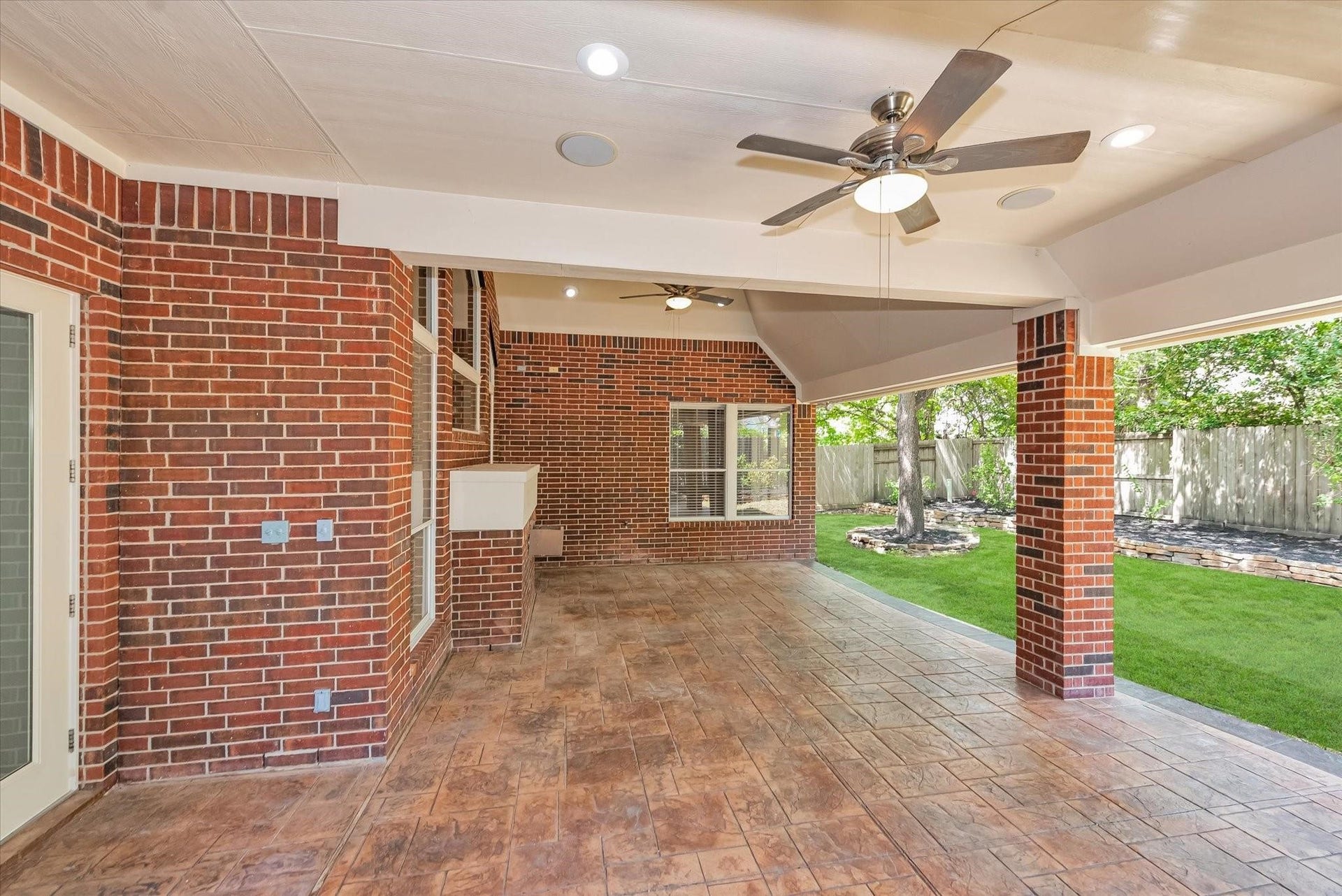 42 S Peaceful Canyon Circle, The Woodlands, TX 77381 Side view of the covered back patio with two ceiling fans to cool you down during the summer heat and large areas perfect for an outdoor table and grill.