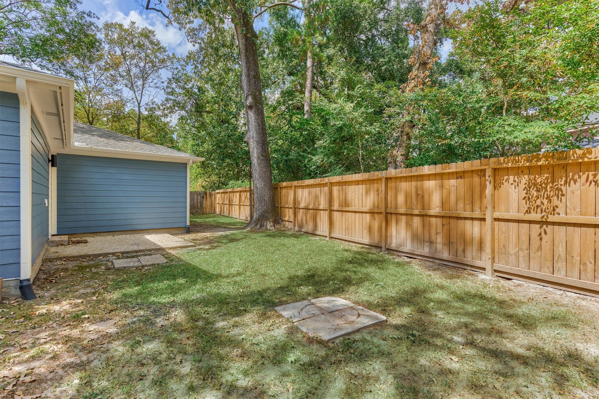 88 W White Willow Circle, The Woodlands, TX 77381 View of the backyard, newer fence, gutters on back of the home are connected to underground drainage.