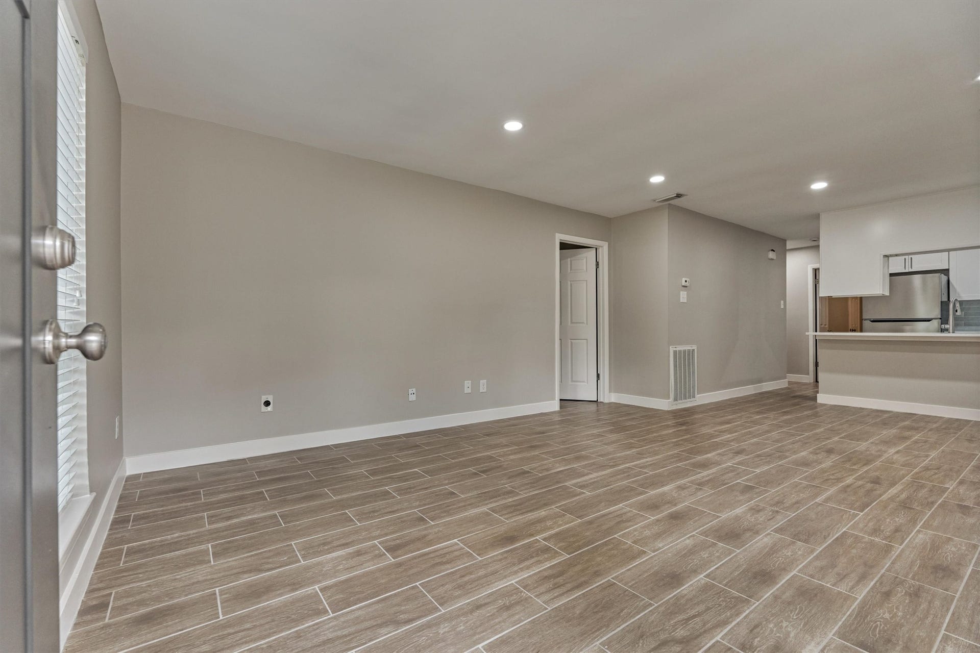 88 W White Willow Circle, The Woodlands, TX 77381 Large open living room with upgraded wood-look tile floors. Neutral colors throughout.