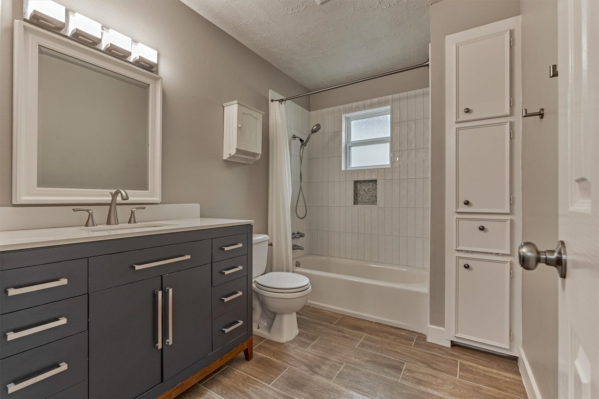 88 W White Willow Circle, The Woodlands, TX 77381 Bathroom #2 - updated with new vanity, framed mirror, modern style tile surround with brushed nickel fixtures and hardware. Handy linen closet and towel hooks.