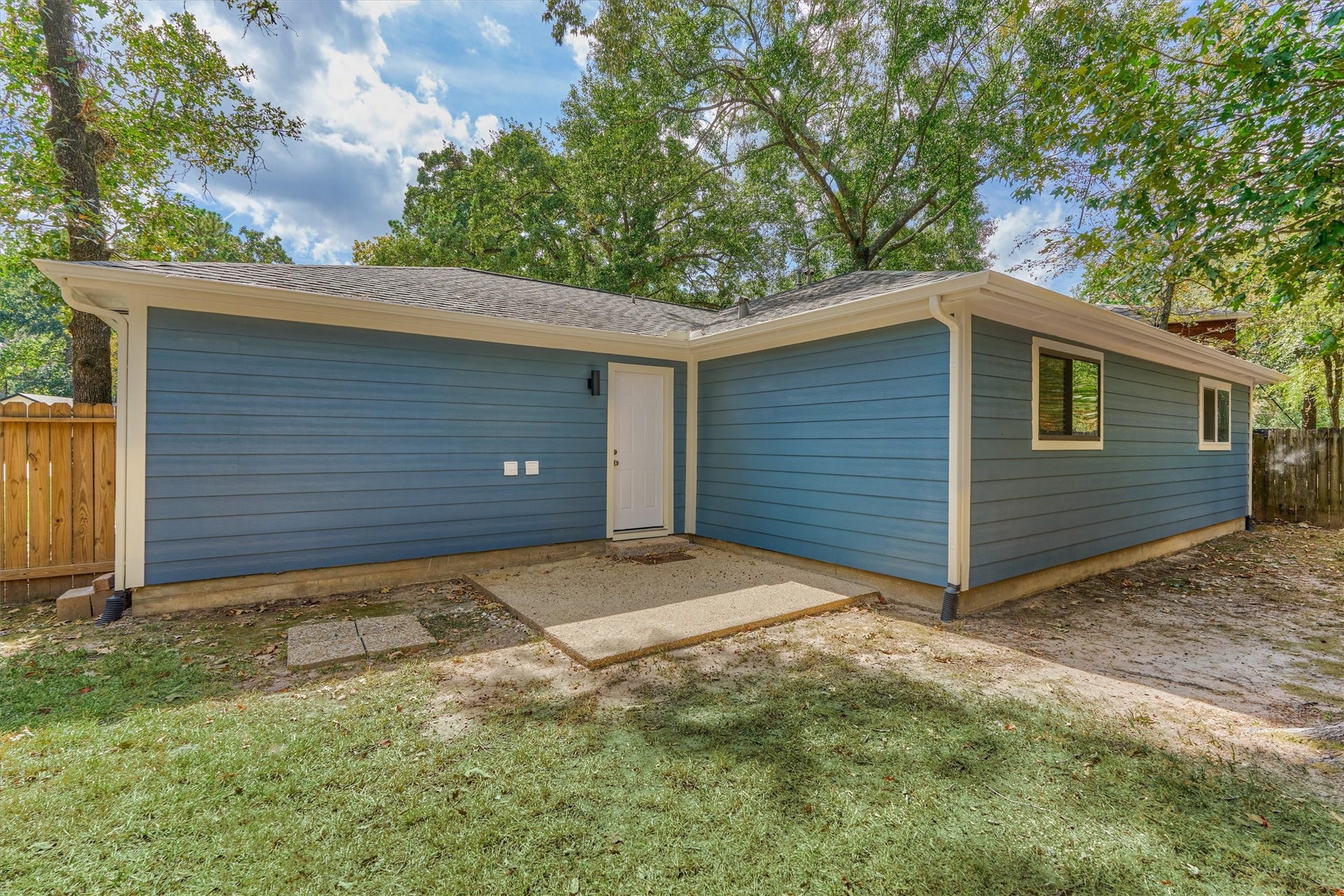 88 W White Willow Circle, The Woodlands, TX 77381 Rear view of the home with small concrete patio.