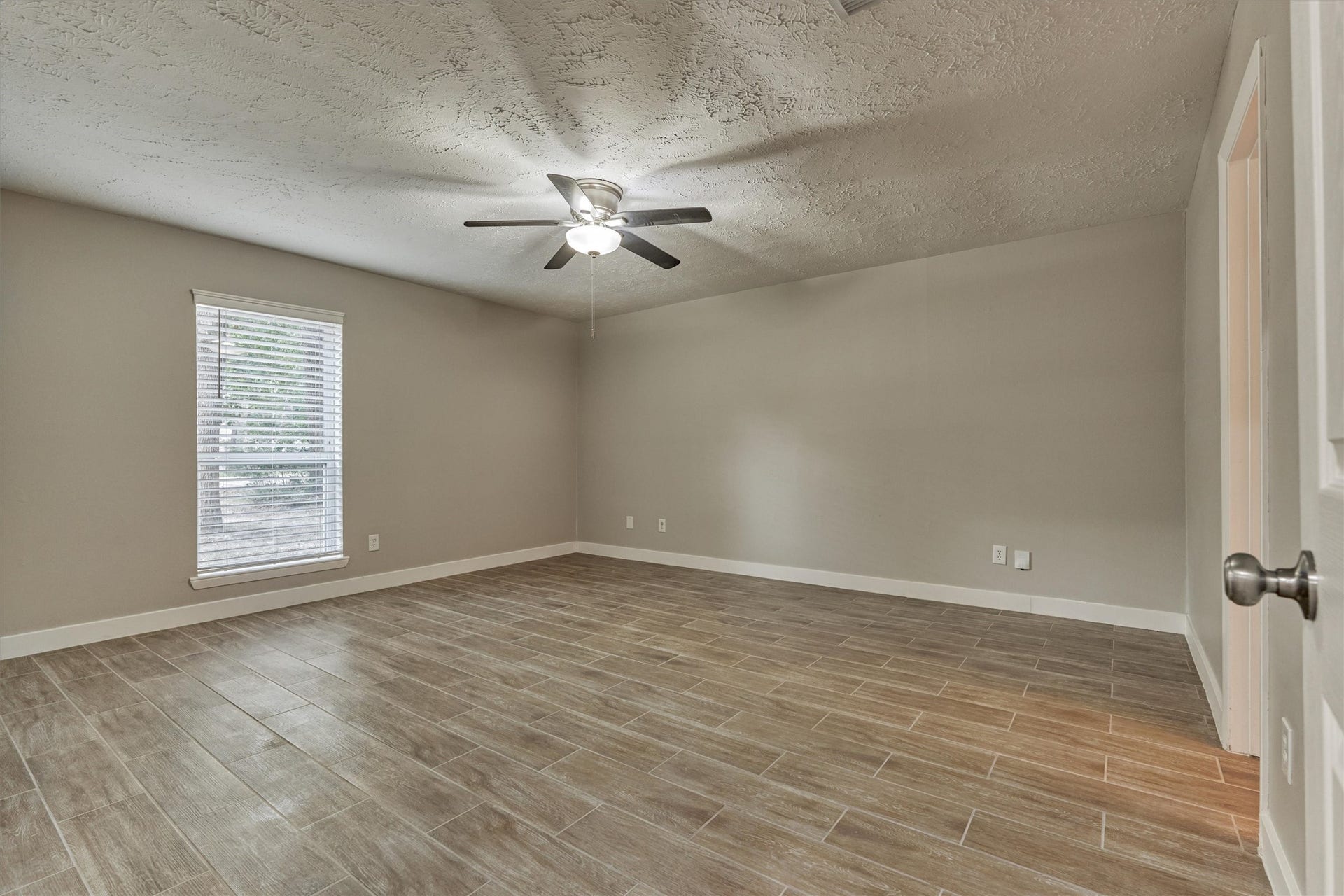 88 W White Willow Circle, The Woodlands, TX 77381 Large primary bedroom overlooking the front yard with wood-look tile floors, ceiling fan and wired for cable.