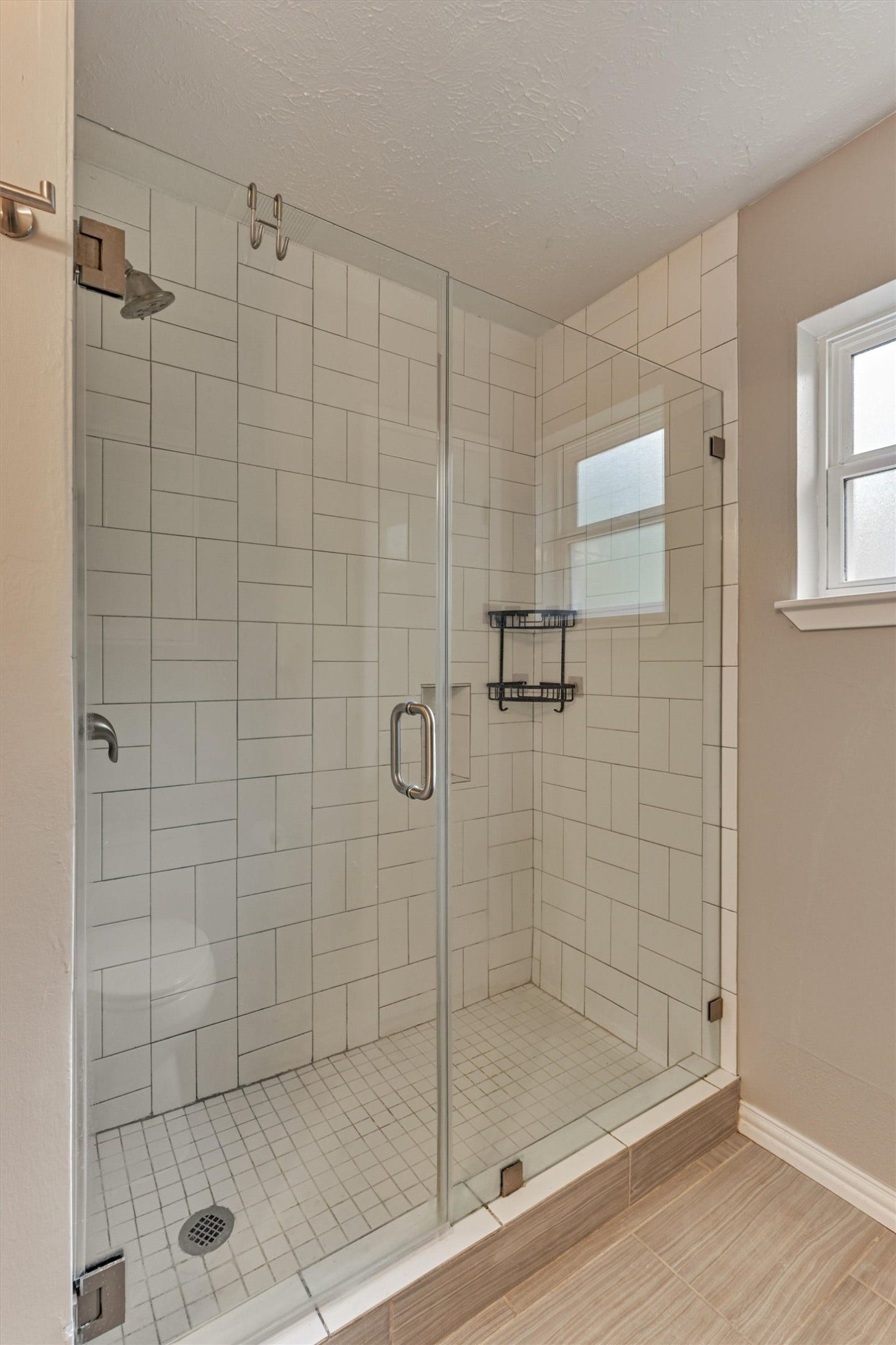88 W White Willow Circle, The Woodlands, TX 77381 Updated frameless primary shower with geometric pattern tile surround and upgraded brushed nickel pluming hardware.
