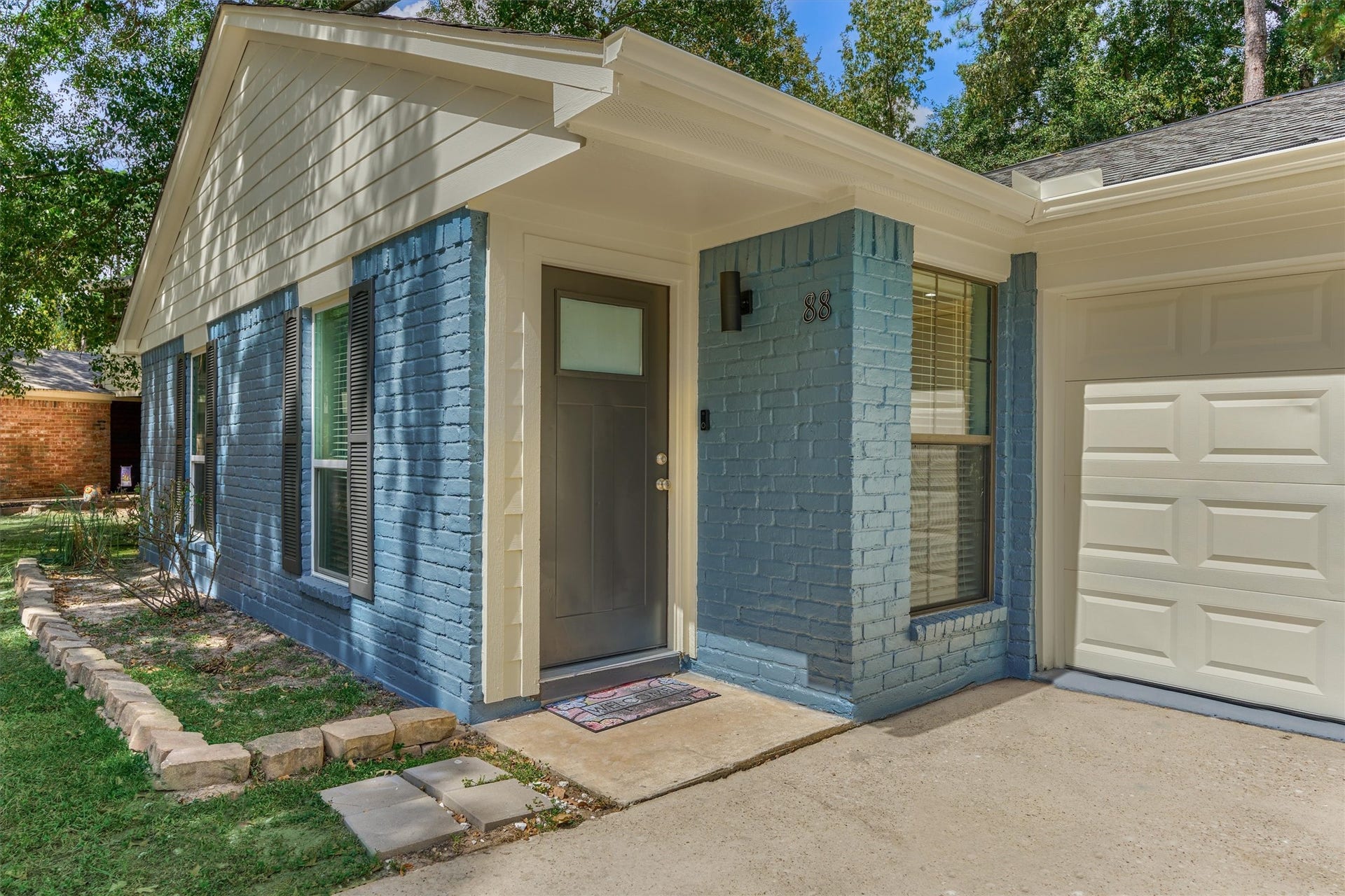 88 W White Willow Circle, The Woodlands, TX 77381 Home exterior was just painted September 2026. Upgraded front door, modern light fixture and gutters to help channel rain away fron front door and garage door.