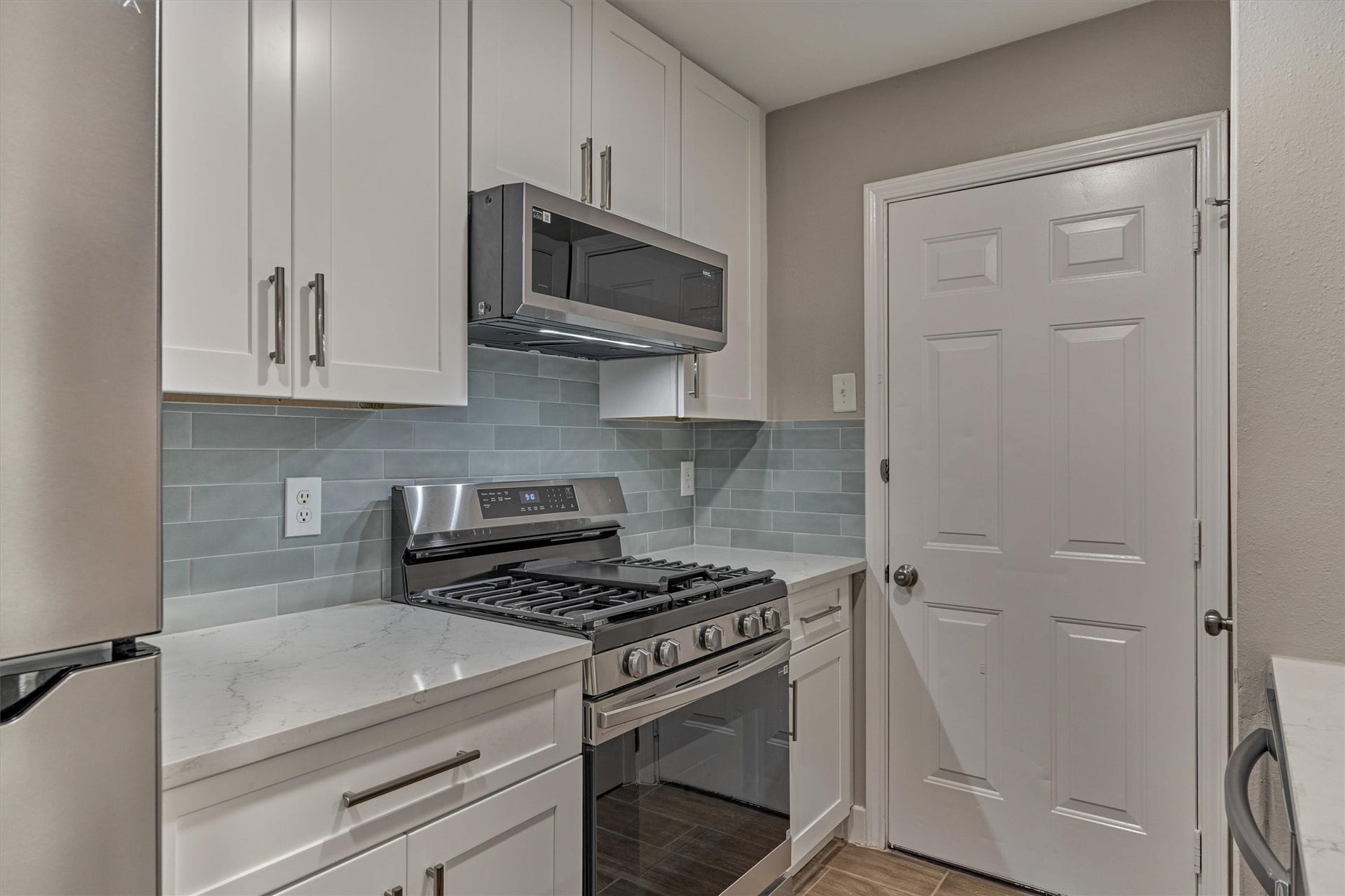 88 W White Willow Circle, The Woodlands, TX 77381 Upgraded new Samsung 5-burner gas range with griddle, Samsung microwave, Samsung dishwasher and soft green/gray backsplash tiile.