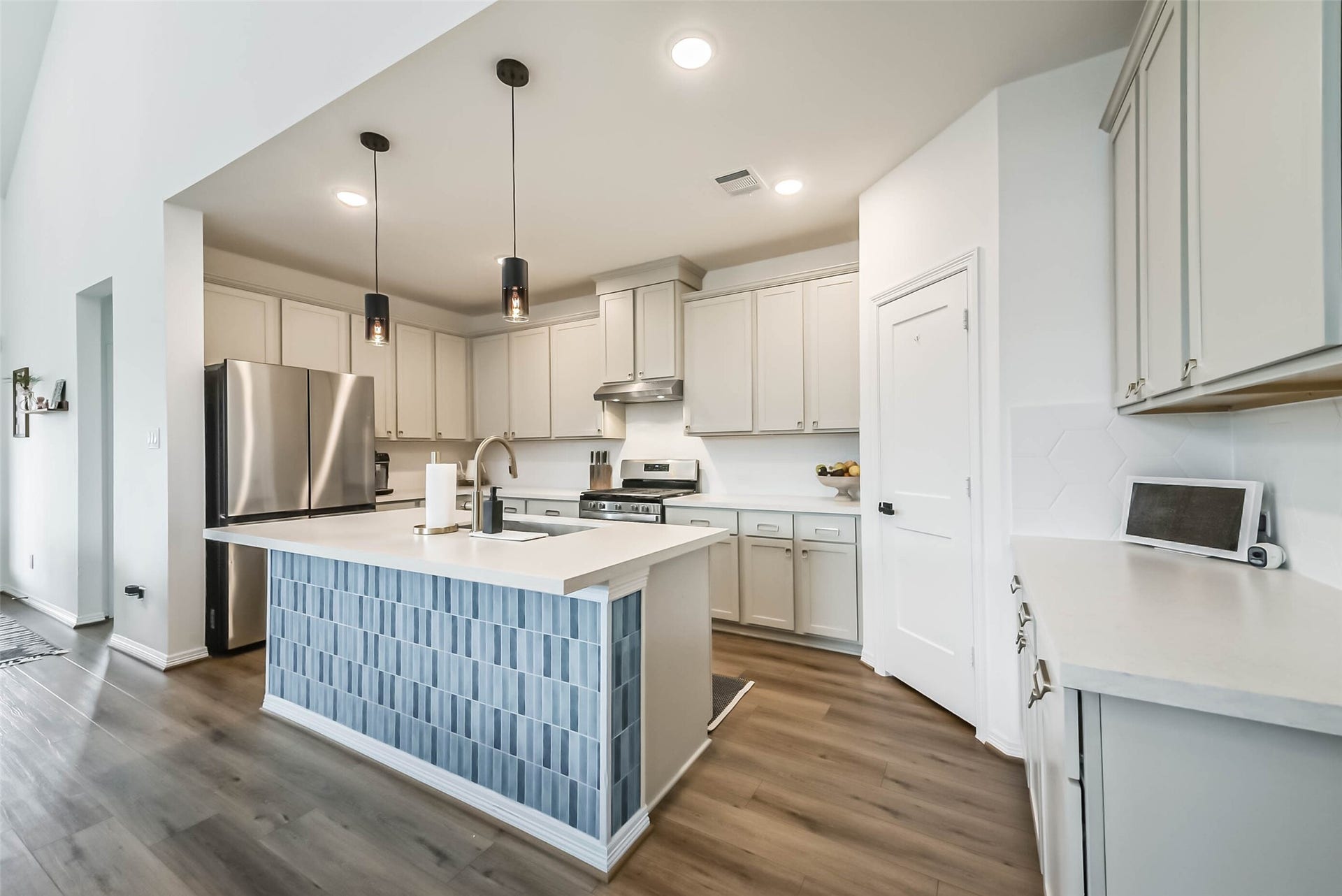 32403 Clouser Crawdad Court, Fulshear, TX 77441 The kitchen has numerous upgrades and features including cabinetry above the refrigerator, new pendant lighting, soft close cabinets and drawers, roll out trash bins, and a custom vent hood.
