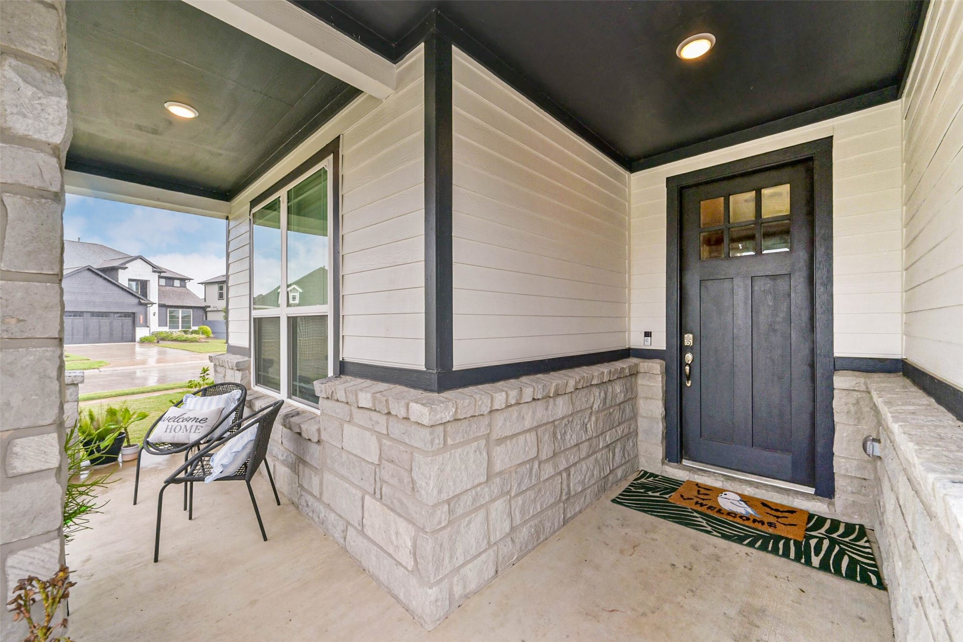 32403 Clouser Crawdad Court, Fulshear, TX 77441 Covered porch with space for sitting and potted plants.