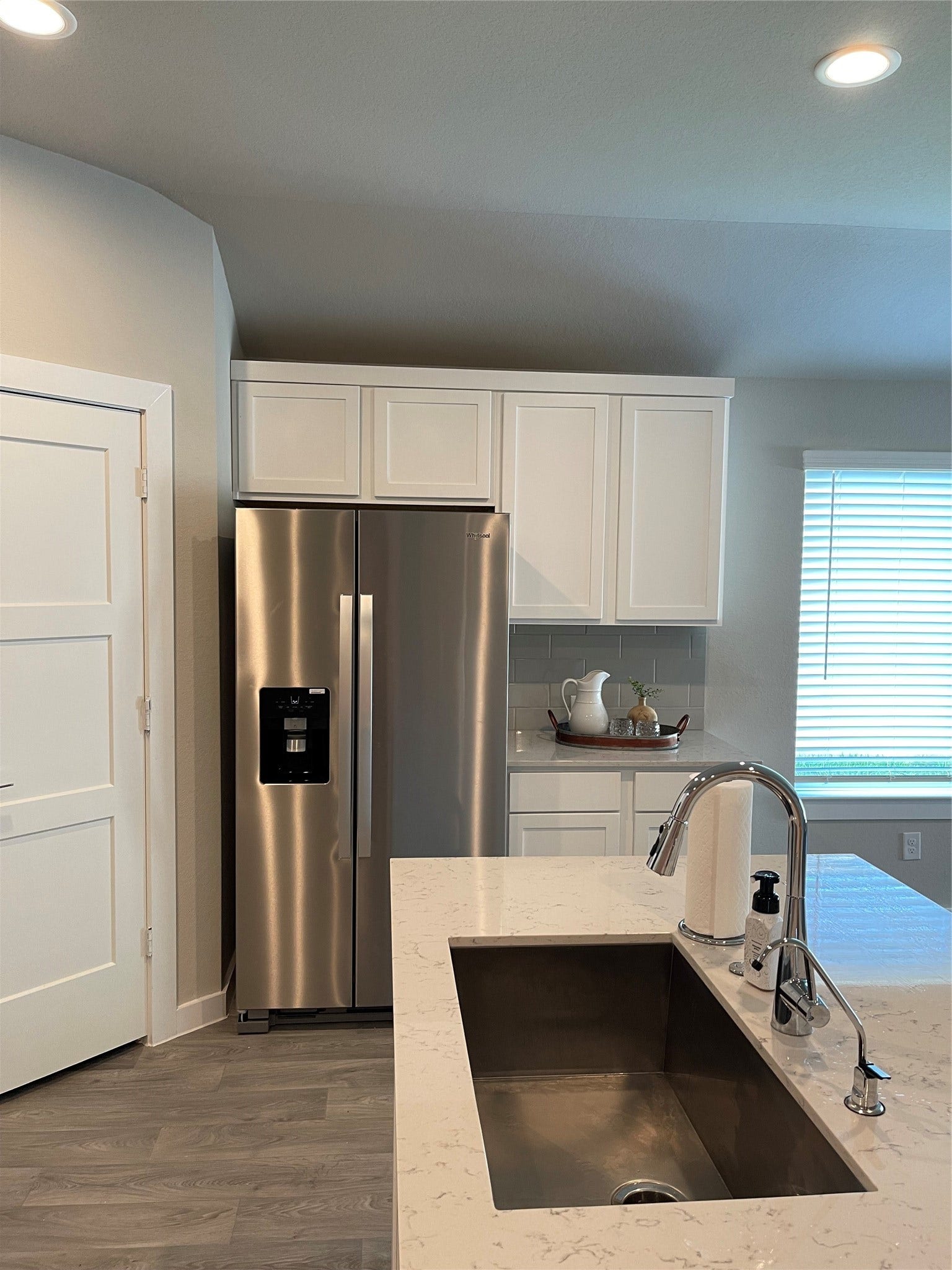 12285 Council Grove Drive, Conroe, TX 77384 Modern kitchen with sleek stainless steel appliances, elegant white cabinetry, and a spacious quartz countertop with an undermount sink.