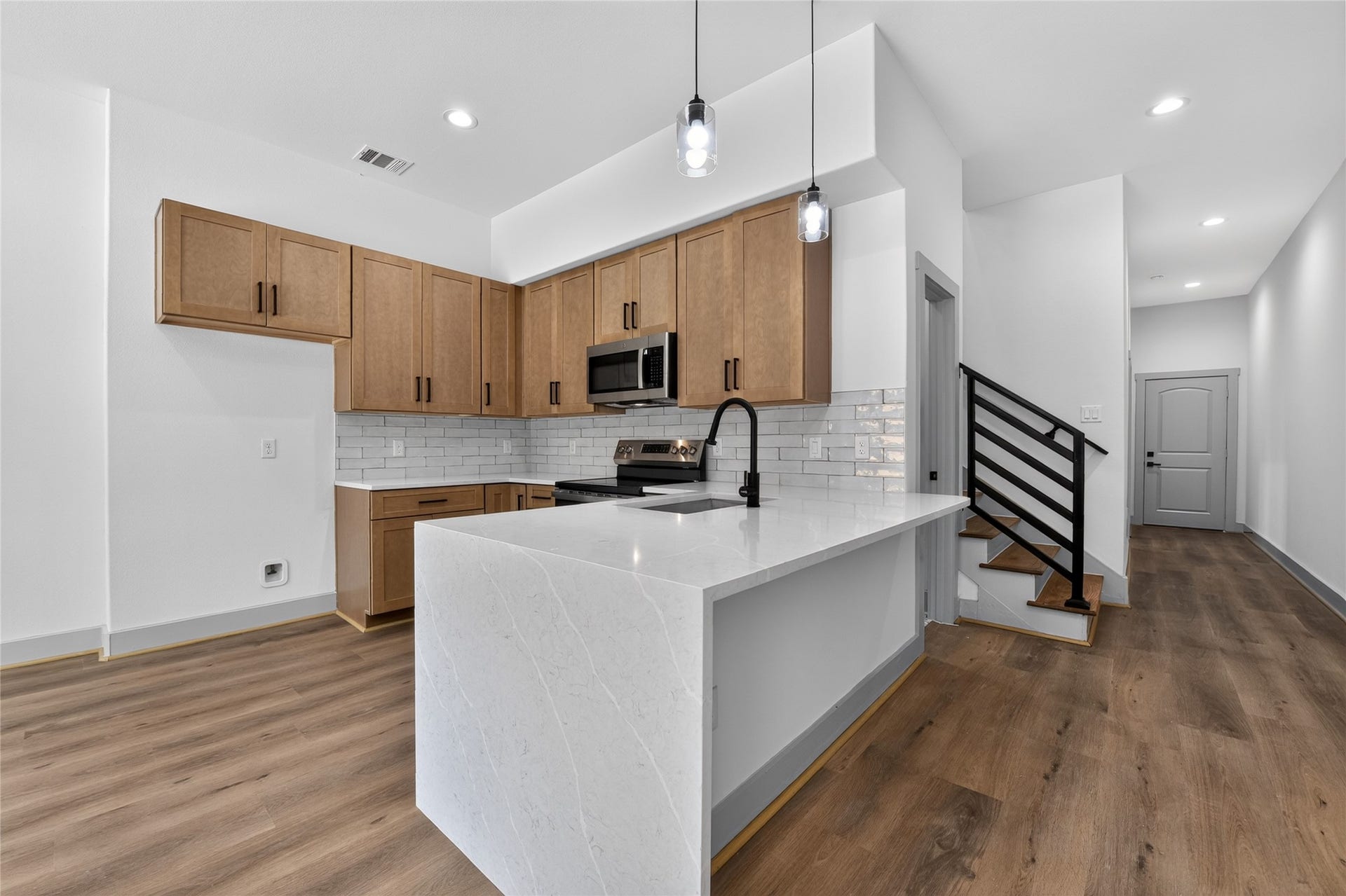 6815 Stearns Street, Houston, TX 77021 A modern hallway provides an elegant separation as it flows directly to the primary suite, the lush backyard, and the second floor.