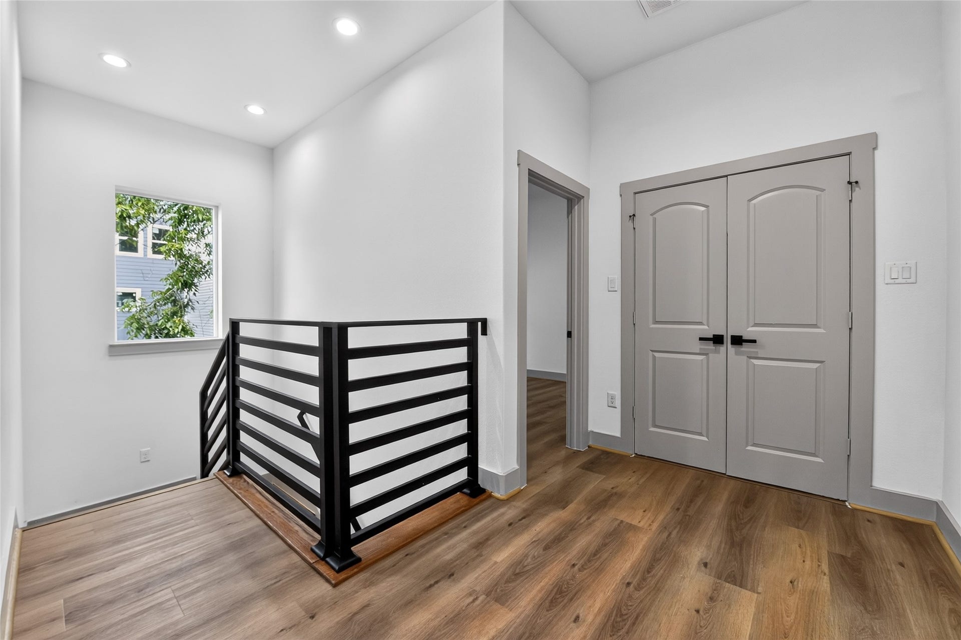 6815 Stearns Street, Houston, TX 77021 A picture window floods the stairway and upper level with warm natural light, illuminating a flexible secondary living space alongside a seamlessly integrated utility closet for optimal modern convenience.